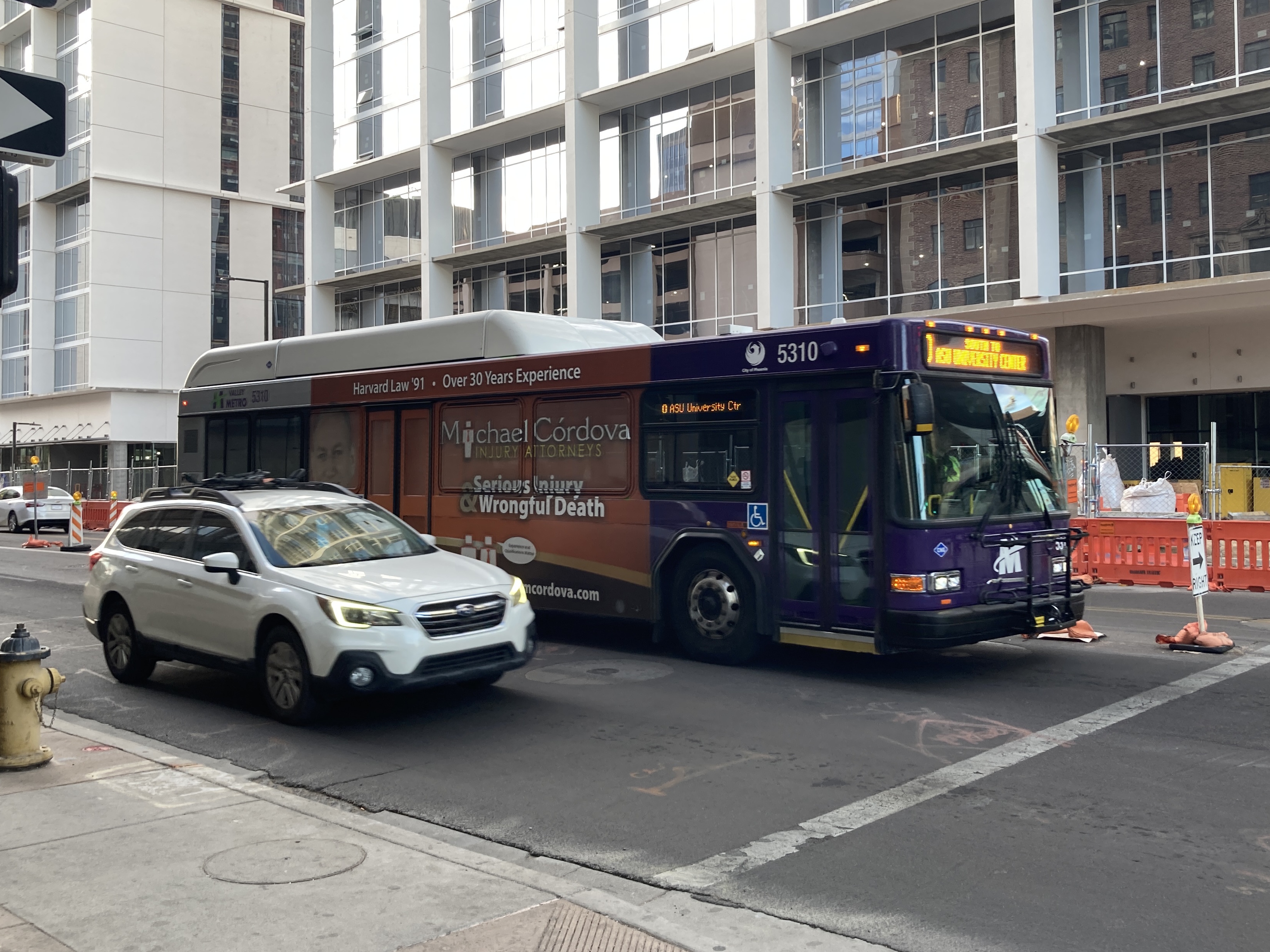 A purple and gray Valley Metro bus, number 5310, traveling eastbound on Van Buren Street in Phoenix on route 0 to ASU University Center