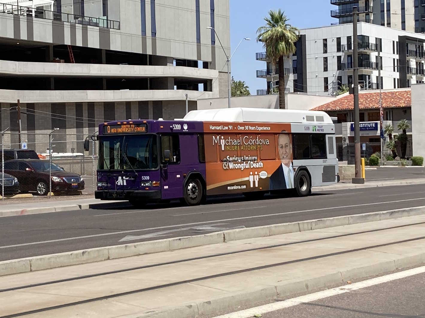 A purple and gray Valley Metro bus, number 5309, traveling southbound on 1st Avenue in Phoenix on route 0 to ASU University Center