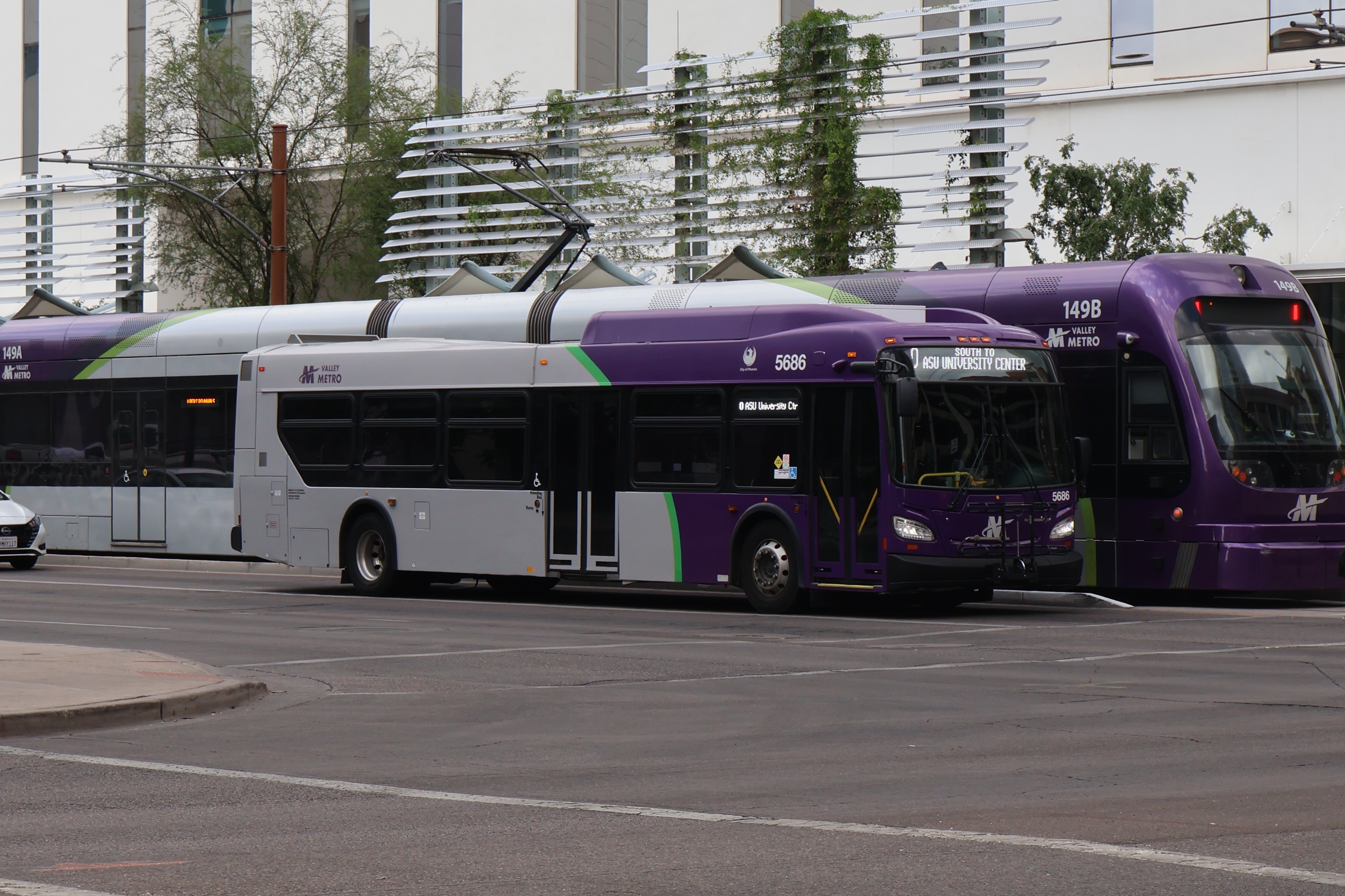 A purple and gray Valley Metro bus, number 5686, traveling southbound on Central Avenue in Phoenix on route 0 to ASU University Center