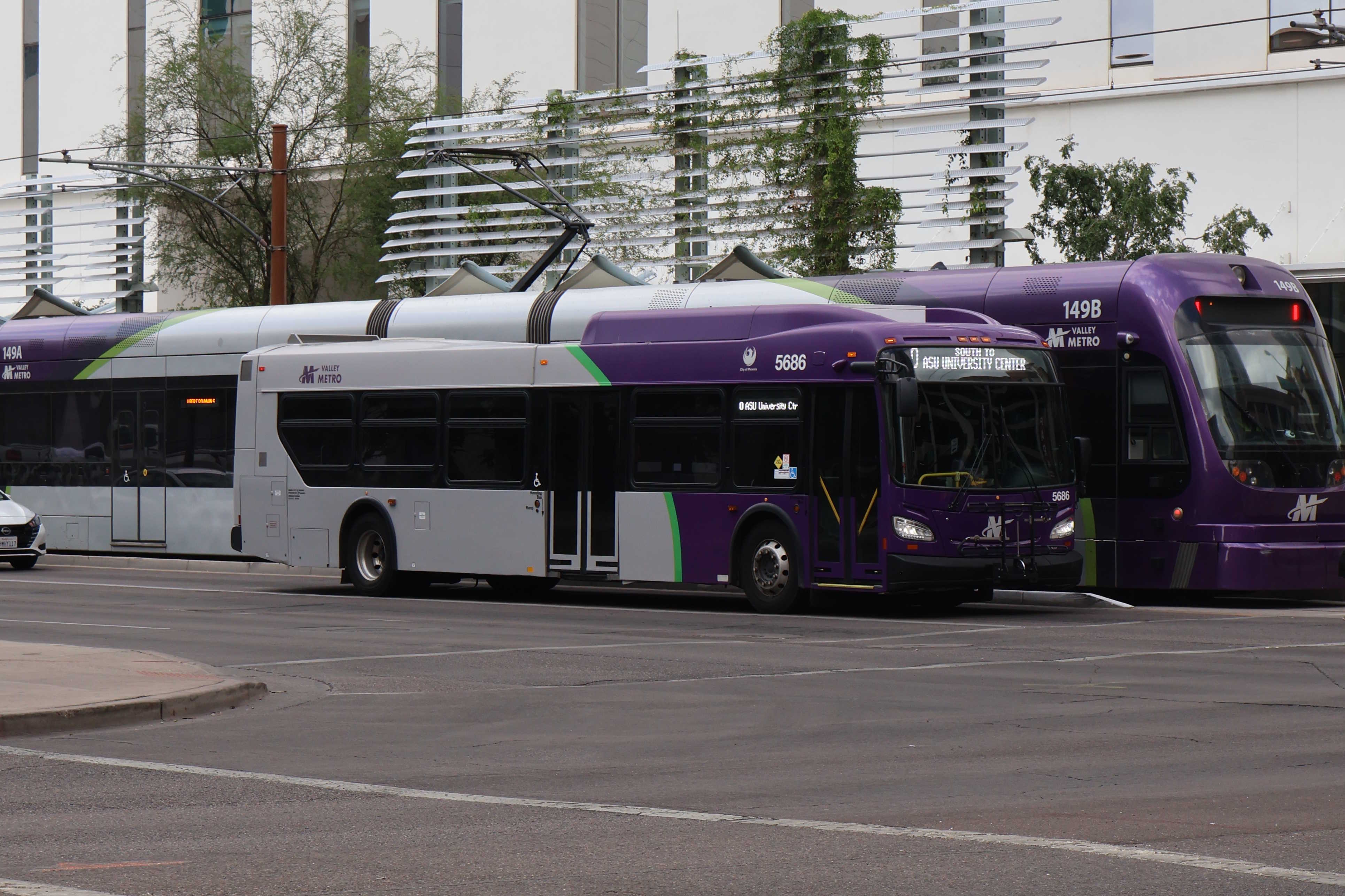 A purple and gray Valley Metro bus, number 5686, traveling southbound on 1st Avenue in Phoenix on route 0 to ASU University Center