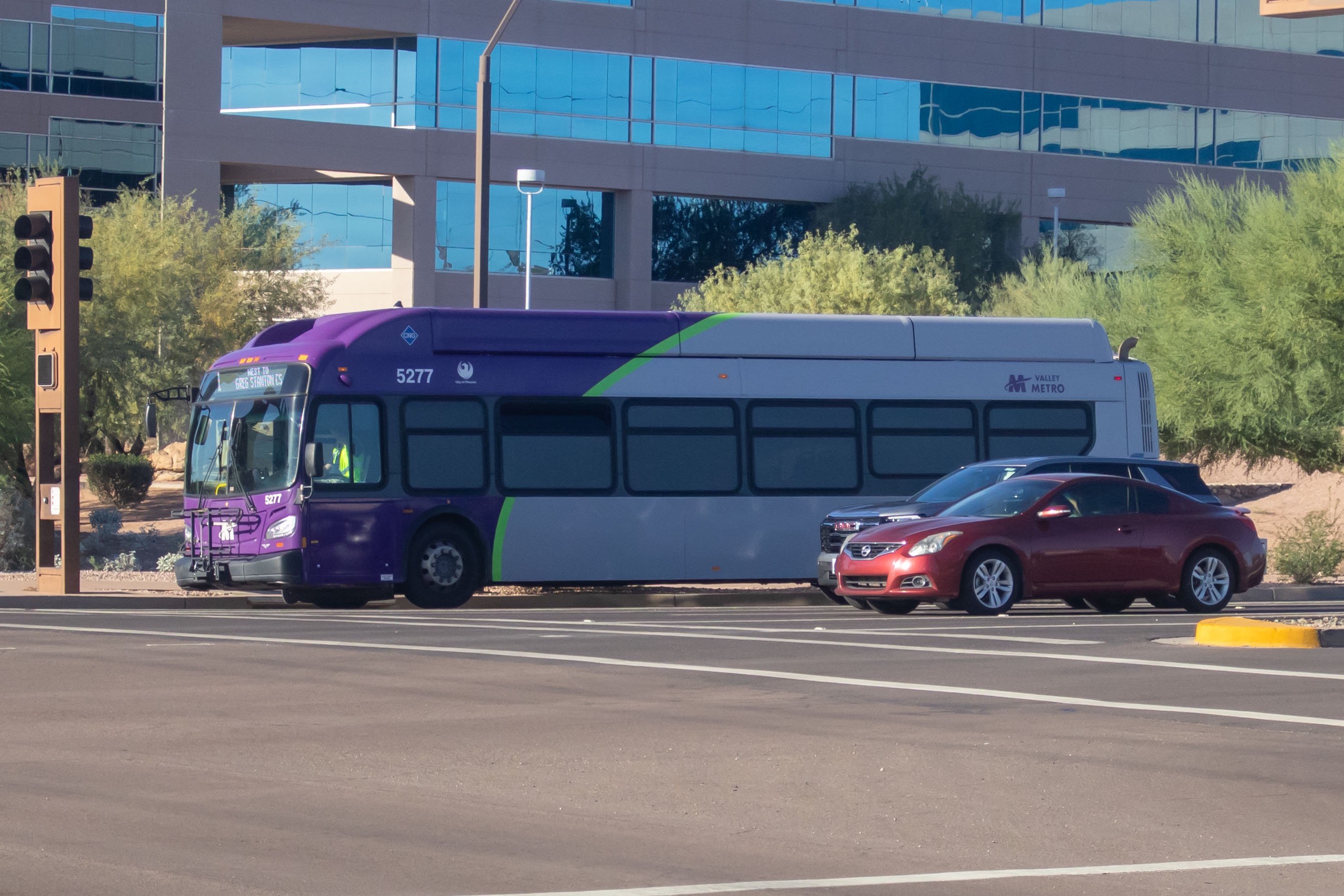 A gray and purple Valley Metro bus, with a green stripe, number 5277, traveling southbound on Priest Drive in Tempe on route 1 to Greg Station Central Station