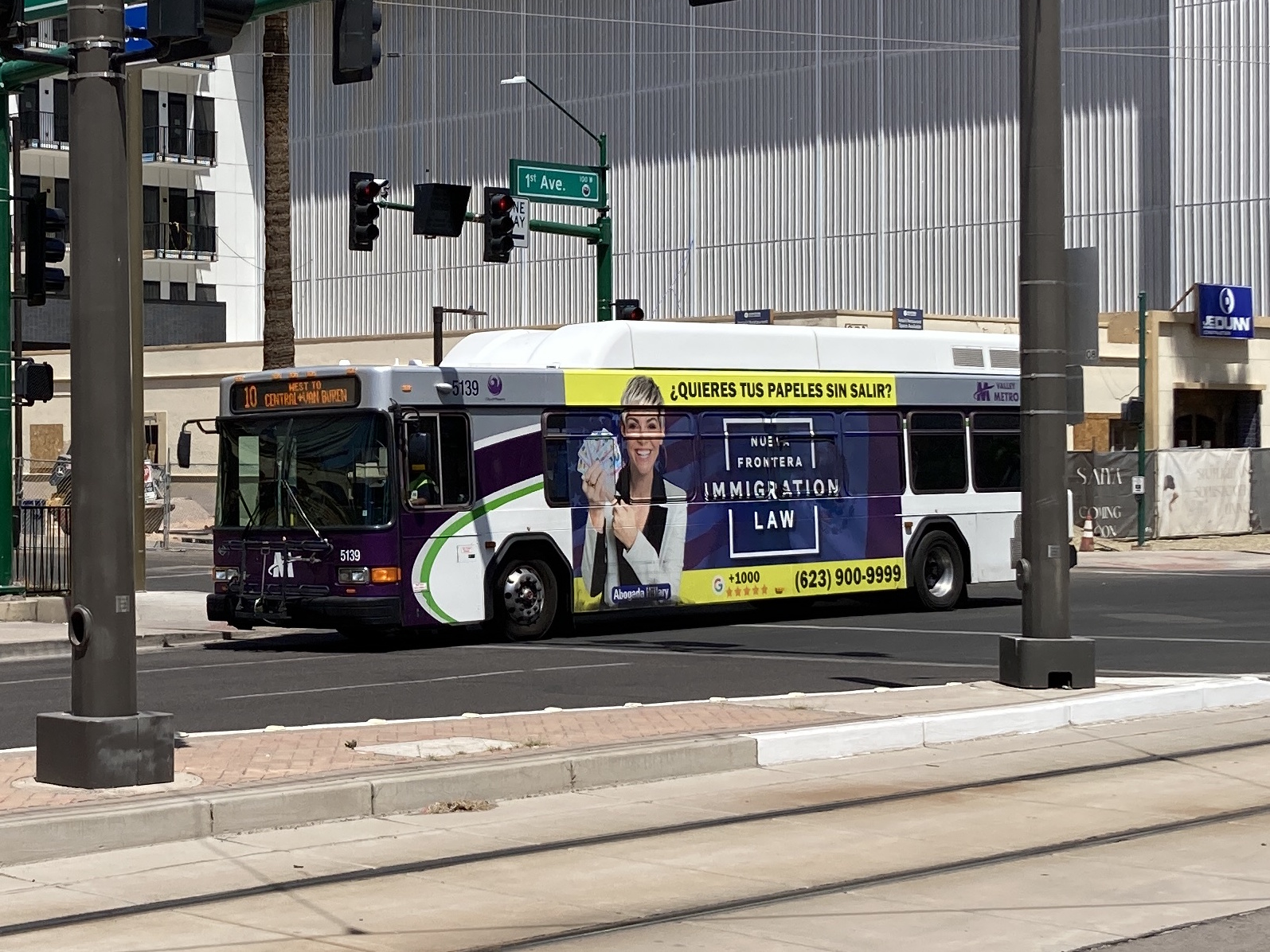 A white and gray Valley Metro bus, with purple and green accent colors, number 5139, traveling southbound on 1st Avenue in Phoenix on route 10 to Van Buren Street and Central Avenue
