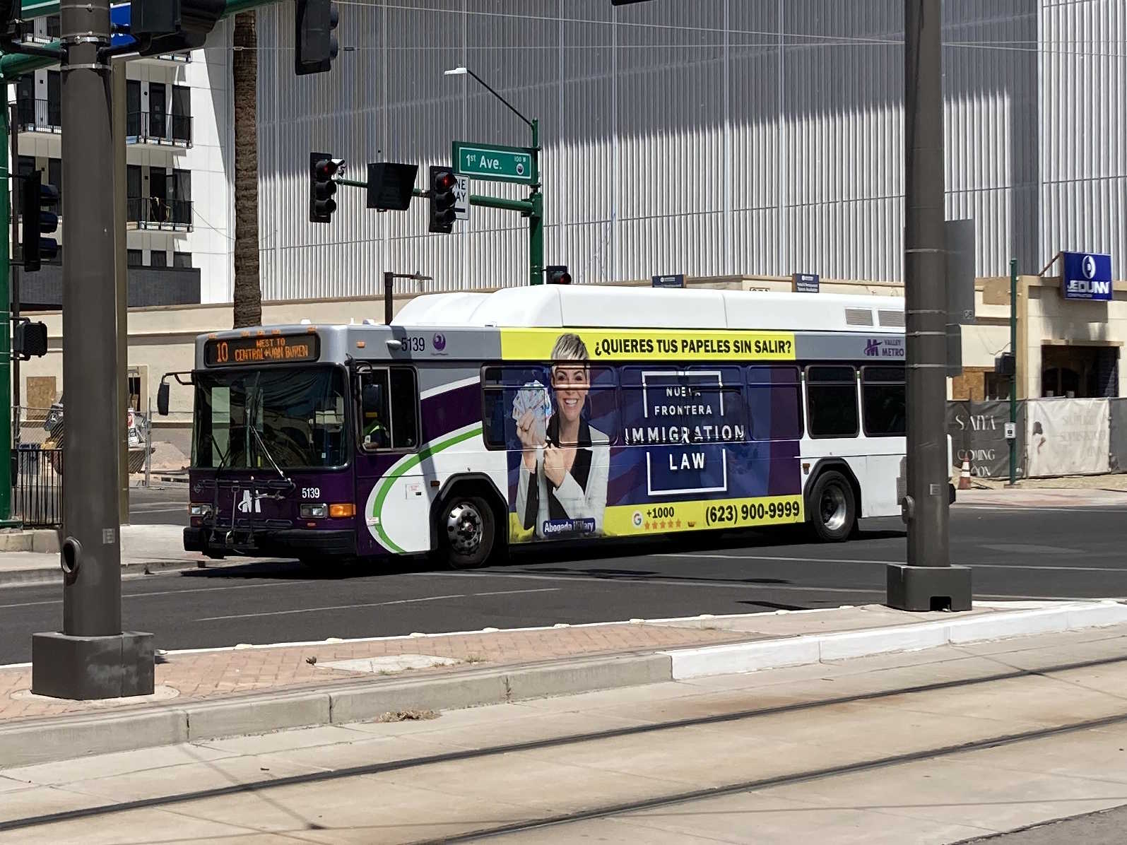 A white and gray Valley Metro bus, with purple and green accent colors, number 5139, traveling southbound on 1st Avenue in Phoenix on route 10 to Van Buren Street and Central Avenue