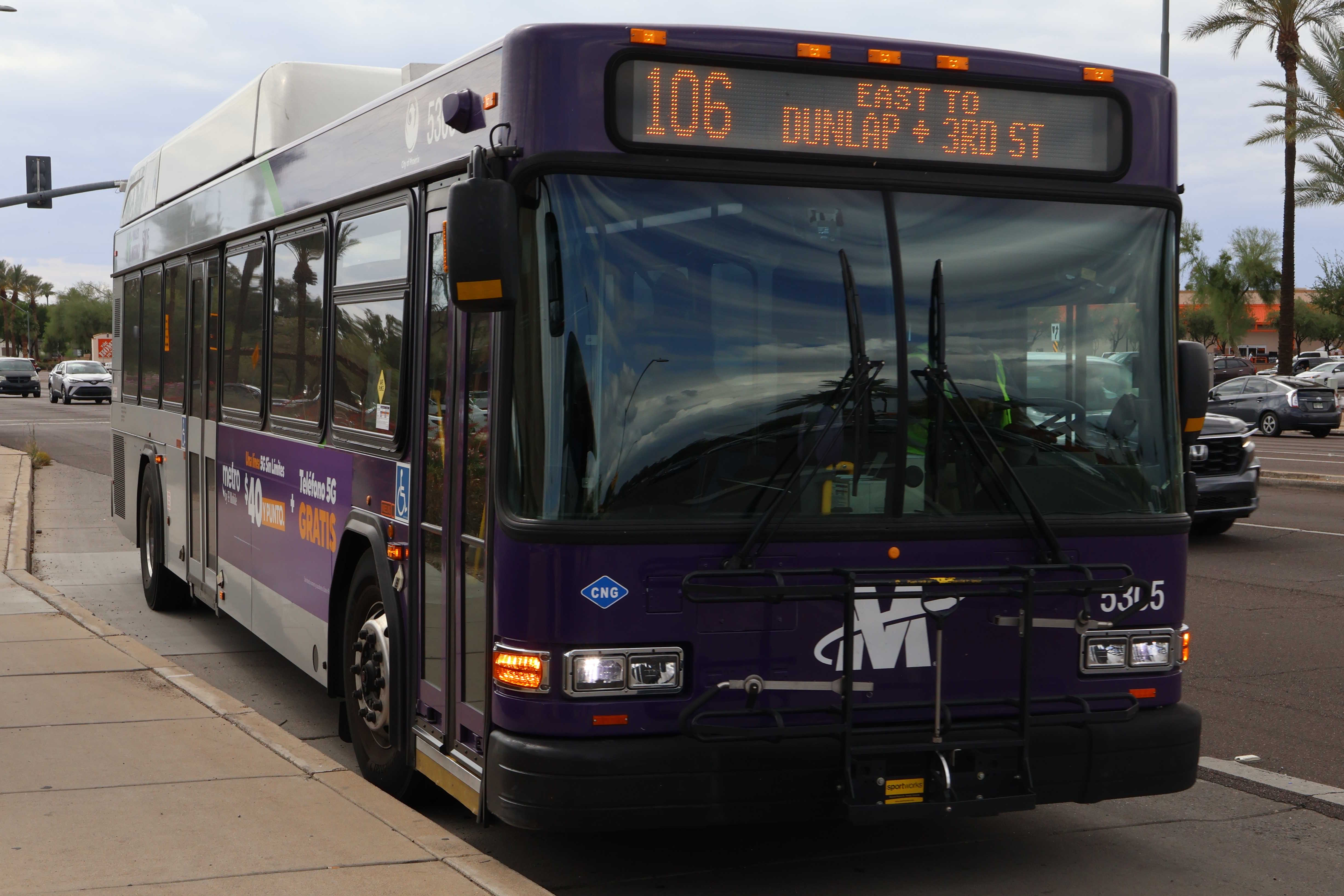 A purple and gray Valley Metro bus, number 5305, traveling eastbound on Peoria Avenue in Glendale on route 106 to Sunnyslope Transit Center