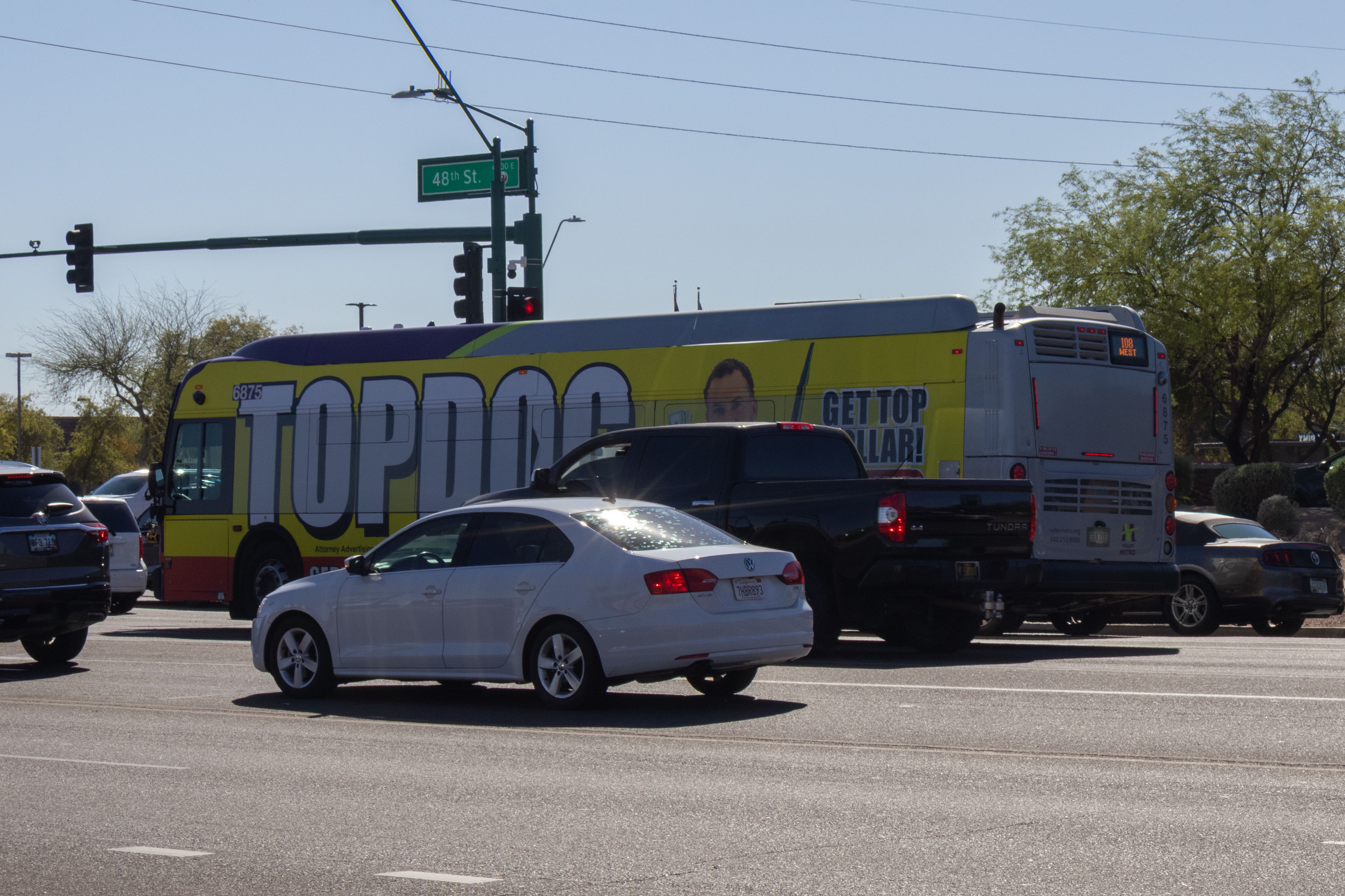 A gray and purple Valley Metro bus, with a green stripe, number 6875, traveling southbound on 48th Street in Phoenix on route 108 to 48th Street and Chandler Boulevard