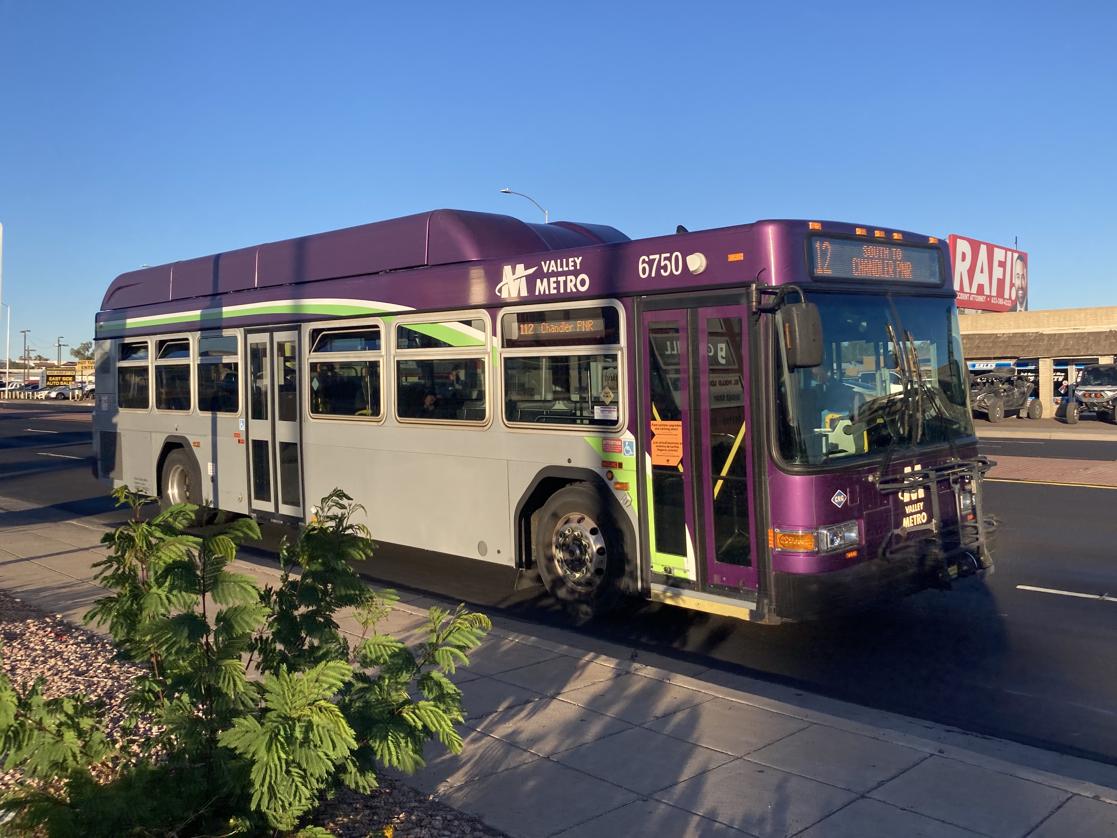 A gray and purple Valley Metro bus, with a white and green stripe, number 6750, traveling southbound on Country Club Drive in Mesa on route 112 to Chandler Park and Ride