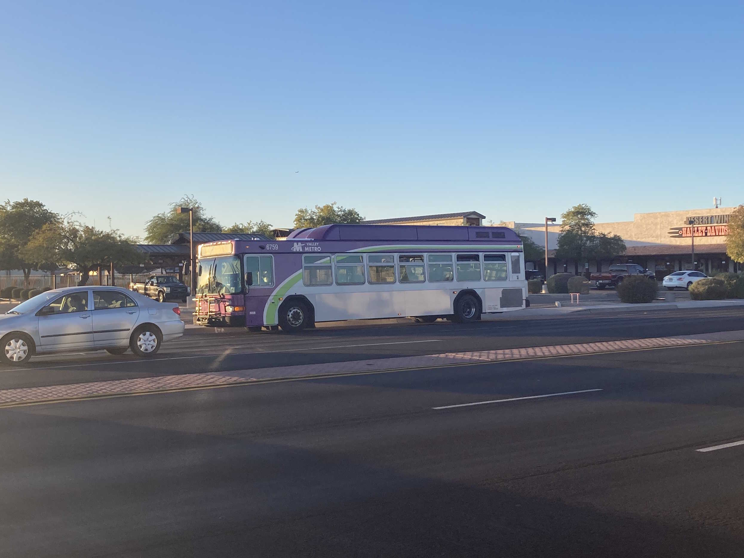 A gray and purple Valley Metro bus, with a white and green stripe, number 6759, traveling southbound on Country Club Drive in Mesa on route 112 to Chandler Park and Ride