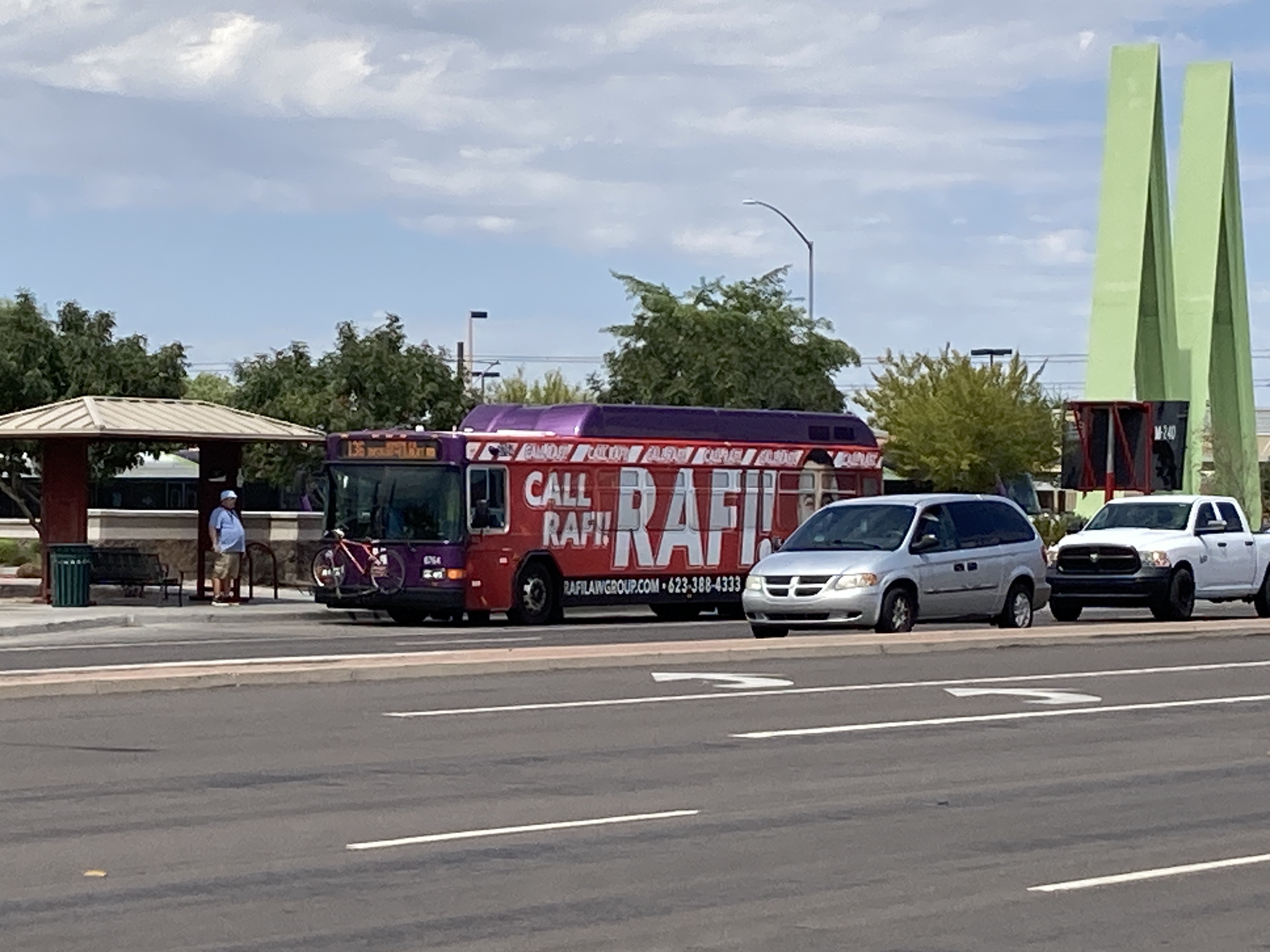 A gray and purple Valley Metro bus, with a white and green stripe, number 6754, traveling southbound on Gilbert Road in Mesa on route 136 to Gilbert Road and Ryan Road