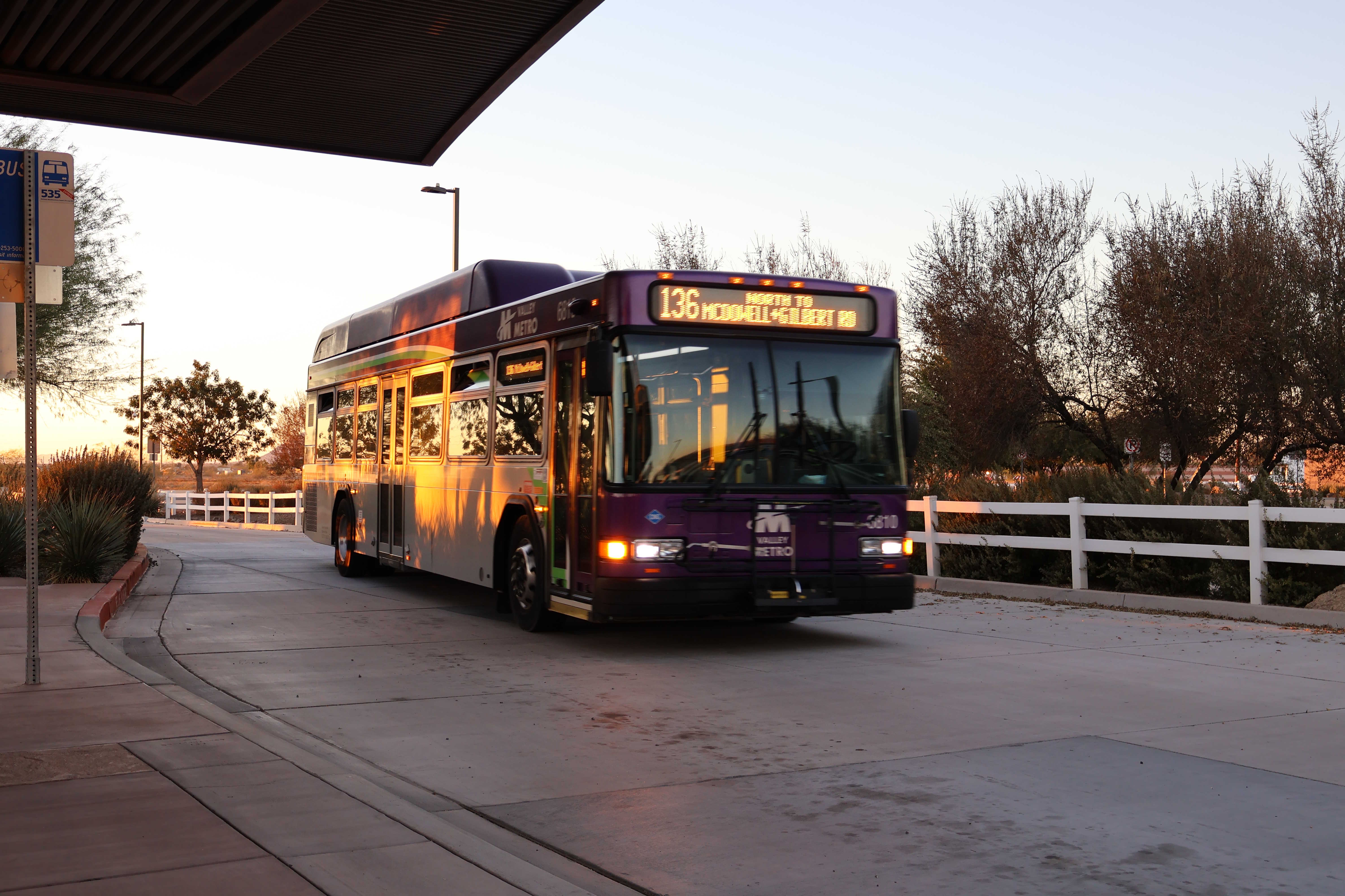 A gray and purple Valley Metro bus, with a white and green stripe, number 6810, at Gilbert Road and McDowell Road Park and Ride in Mesa on route 136 to Gilbert Road and McDowell Road