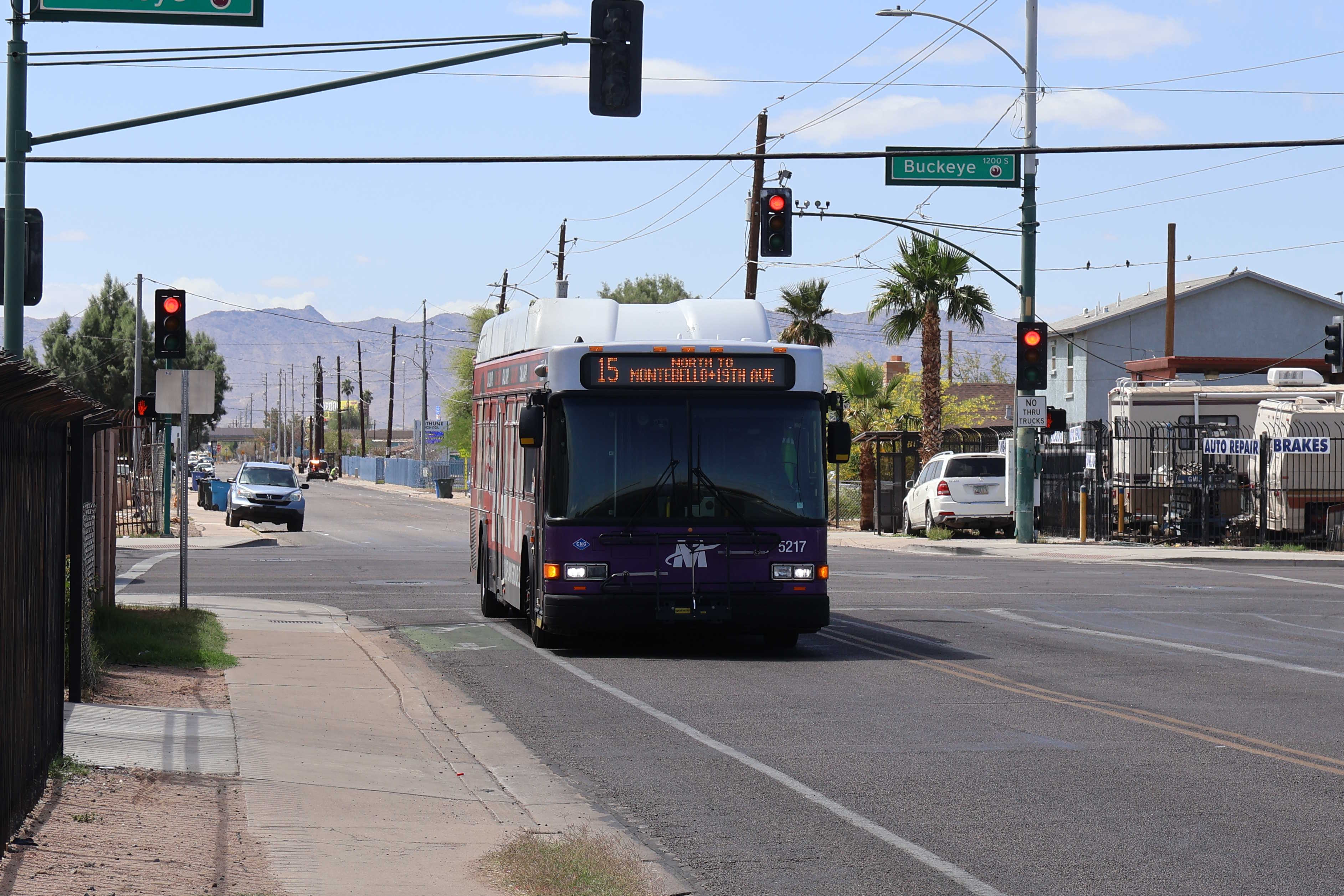 A white and gray Valley Metro bus, with purple and green accent colors, number 5217, traveling northbound on 15th Avenue in Phoenix on route 15 to Montebello / 19th Avenue Transit Center