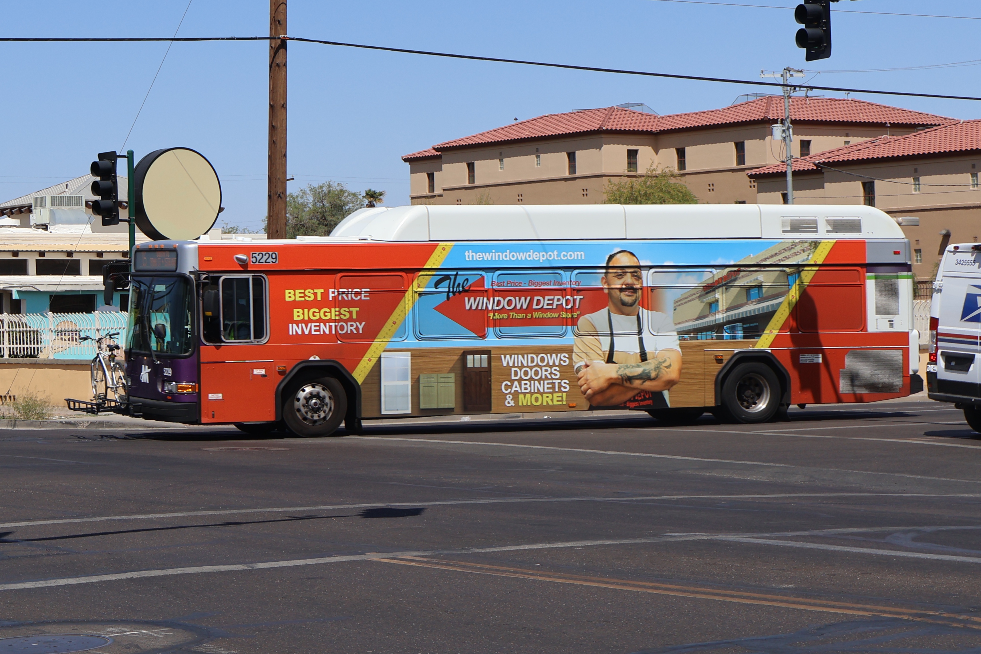 A white and gray Valley Metro bus, with purple and green accent colors, number 5229, traveling southbound on 15th Avenue in Phoenix on route 15 to 15th Avenue and Pima Street