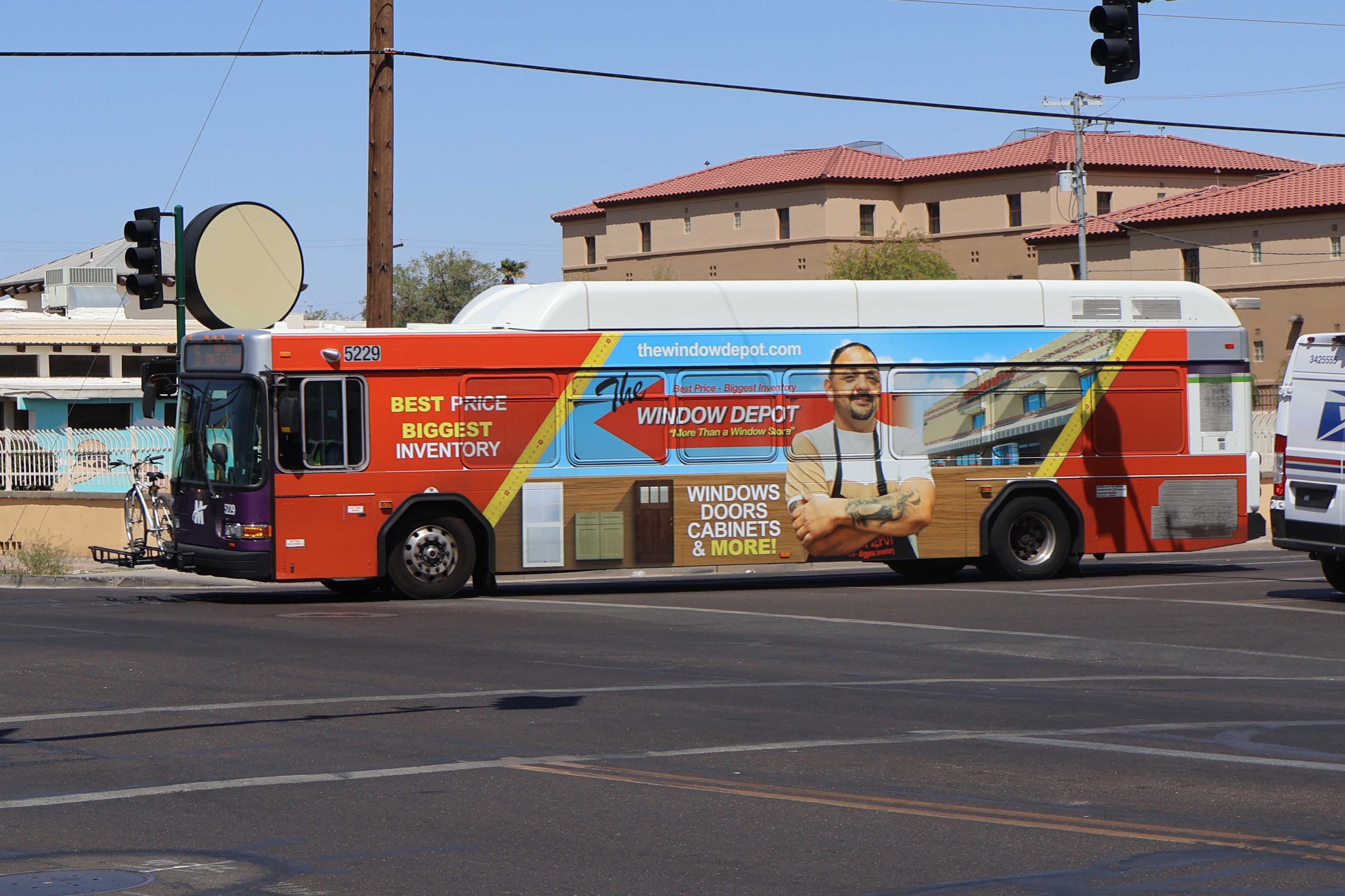 A white and gray Valley Metro bus, with purple and green accent colors, number 5229, traveling southbound on 15th Avenue in Phoenix on route 15 to 15th Avenue and Pima Street