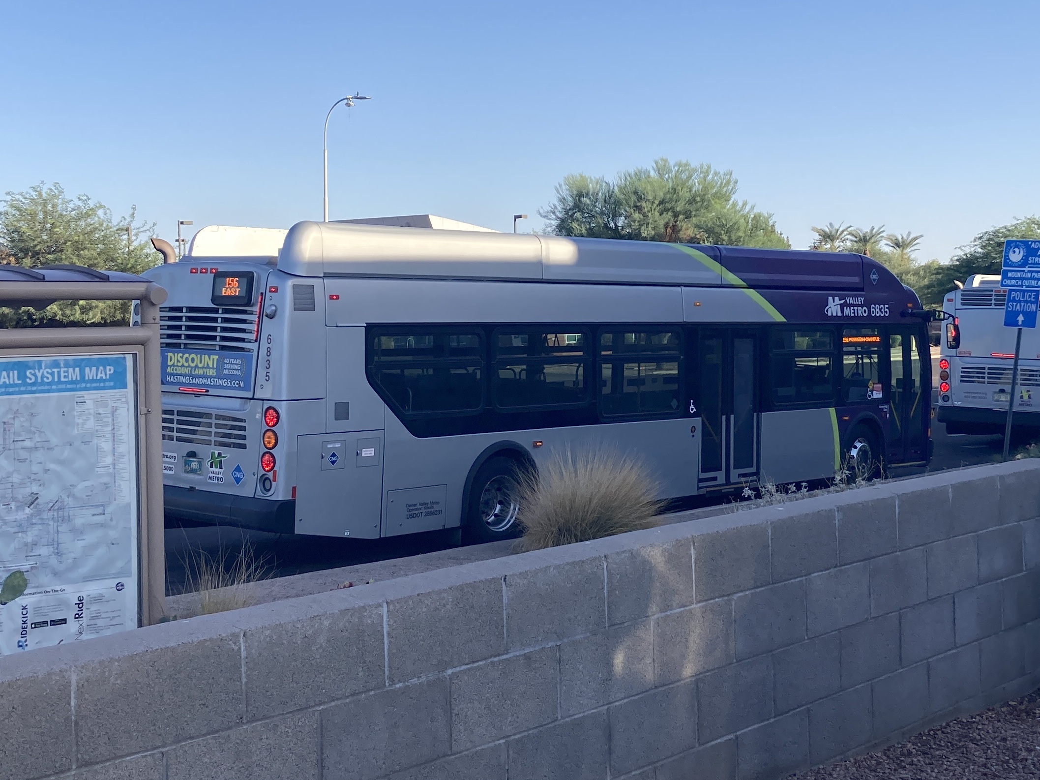 A gray and purple Valley Metro bus, with a green stripe, number 6835, traveling southbound on 48th Street in Phoenix on route 156 to Chandler Boulevard and McQueen Road