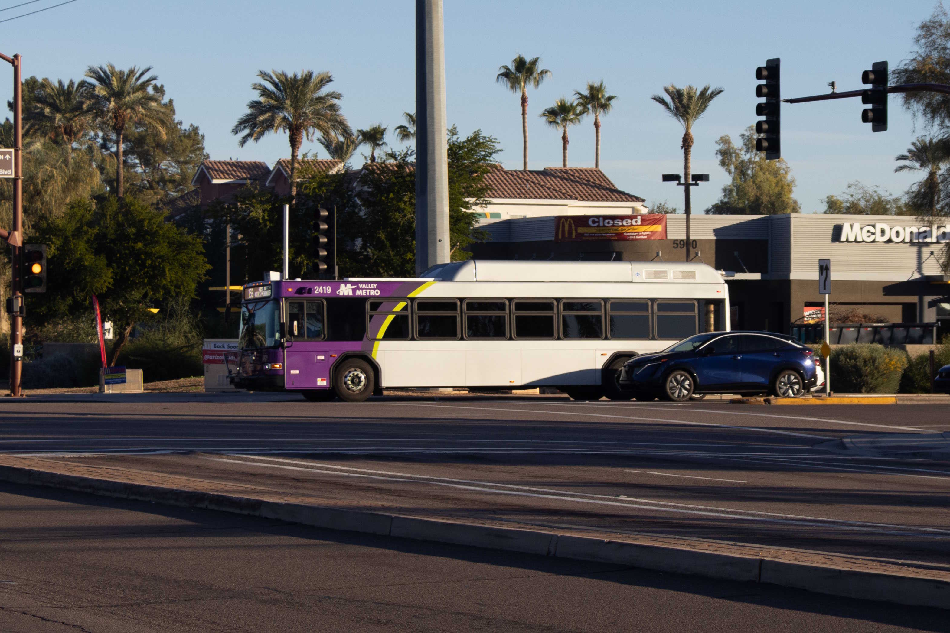 A gray and purple Valley Metro bus, with a green stripe, number 2419, traveling westbound on Chandler Boulevard in Chandler on route 156 to 48th Street and Chandler Boulevard