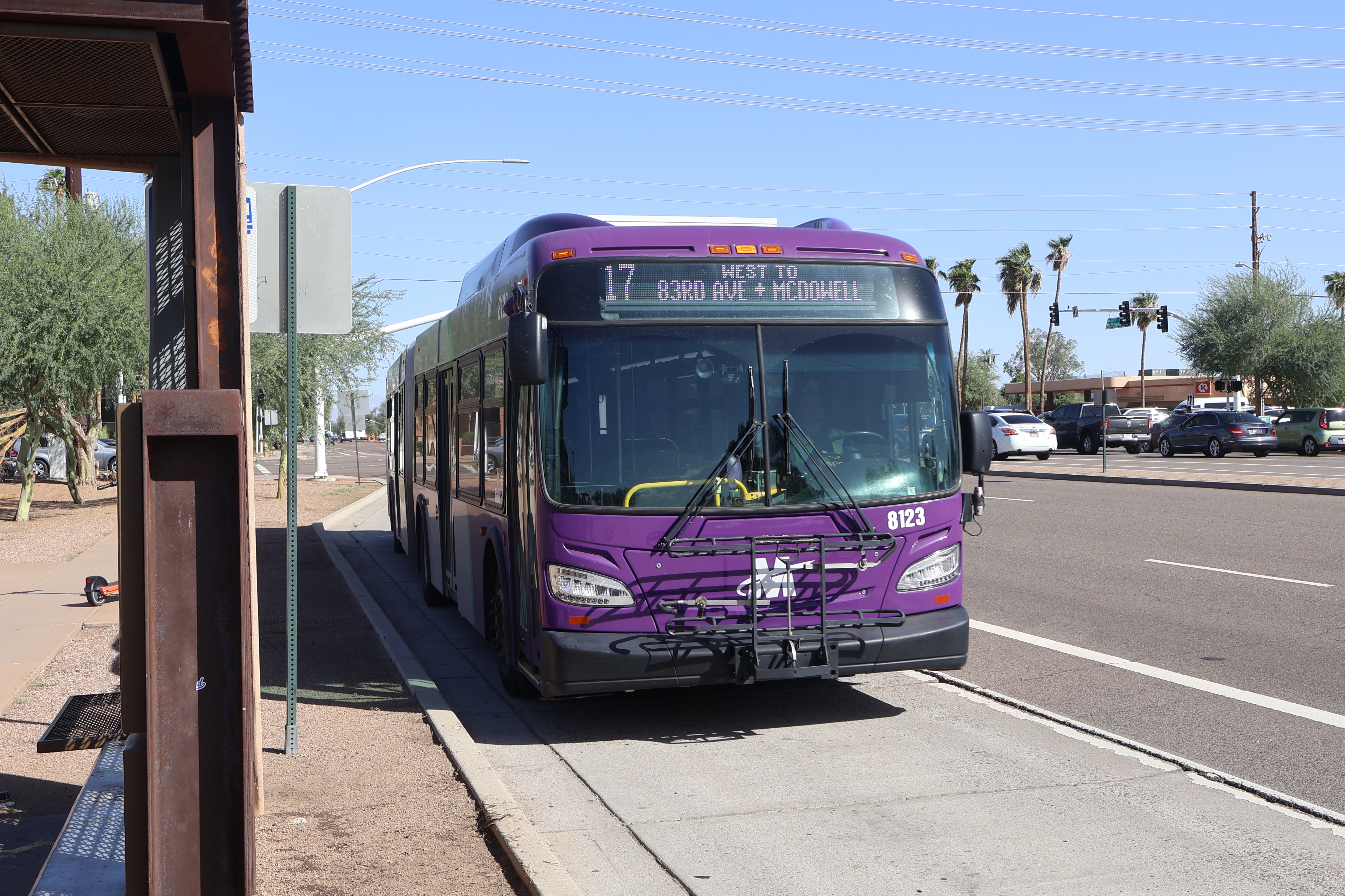 A purple and gray articulated Valley Metro bus, number 8123, traveling westbound on McDowell Road in Scottsdale on route 17 to McDowell Road and 83rd Avenue