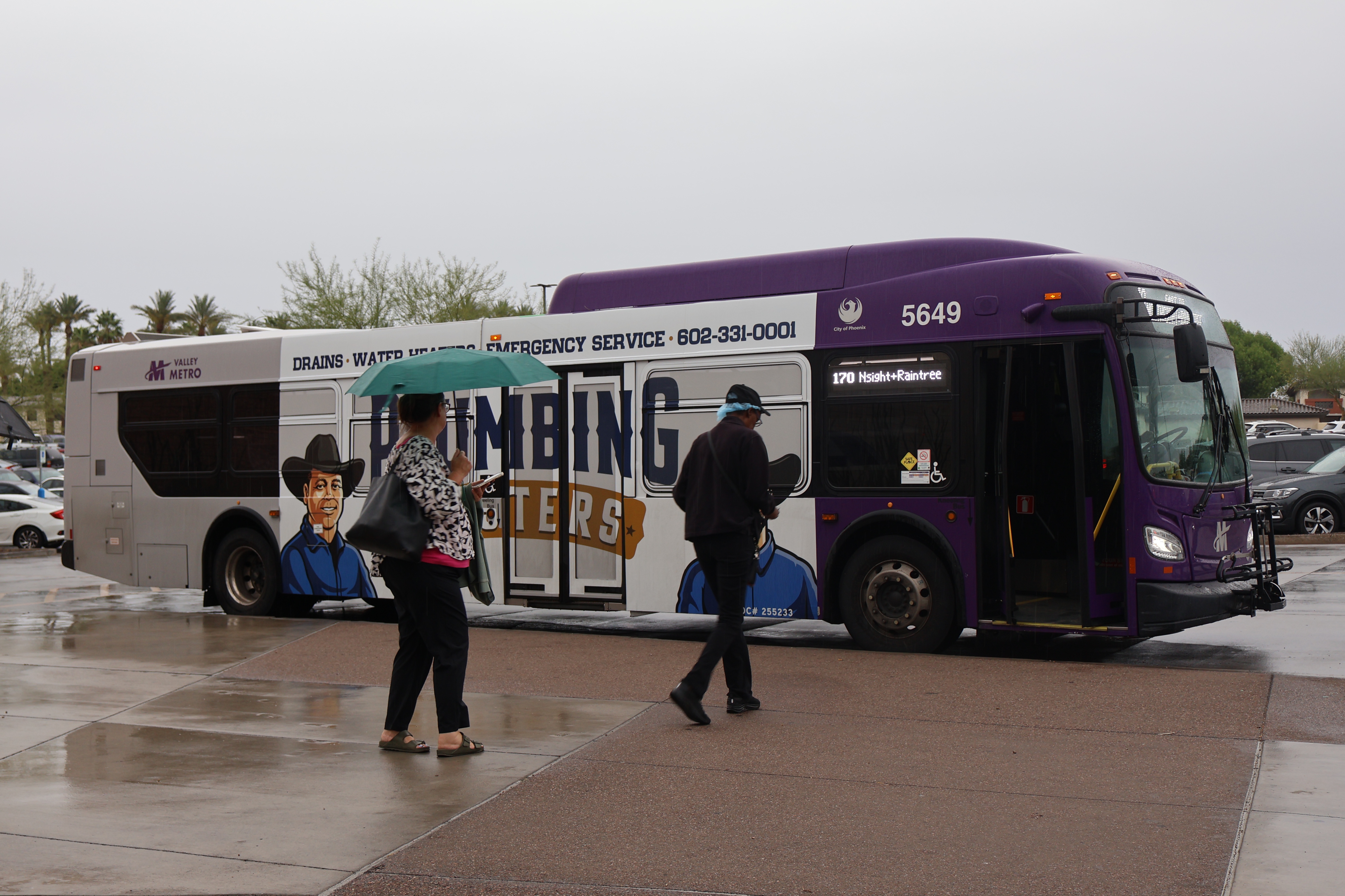 A gray and purple Valley Metro bus, with a green stripe, number 5649, at Arrowhead Mall Transit Center in Glendale on route 170 to Raintree Drive and Northsight Boulevard