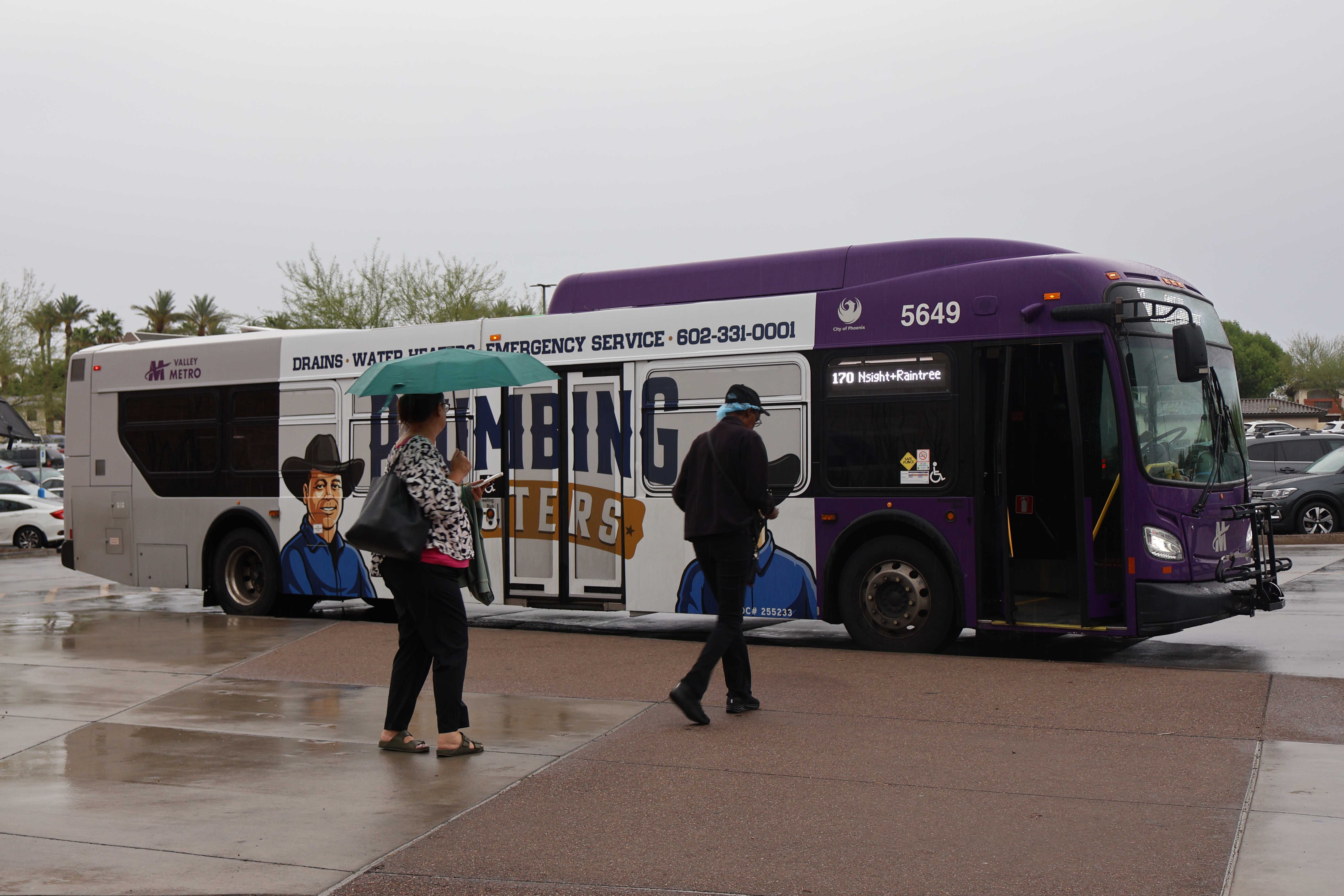 A gray and purple Valley Metro bus, with a green stripe, number 5649, at Arrowhead Mall Transit Center in Glendale on route 170 to Raintree Drive and Northsight Boulevard