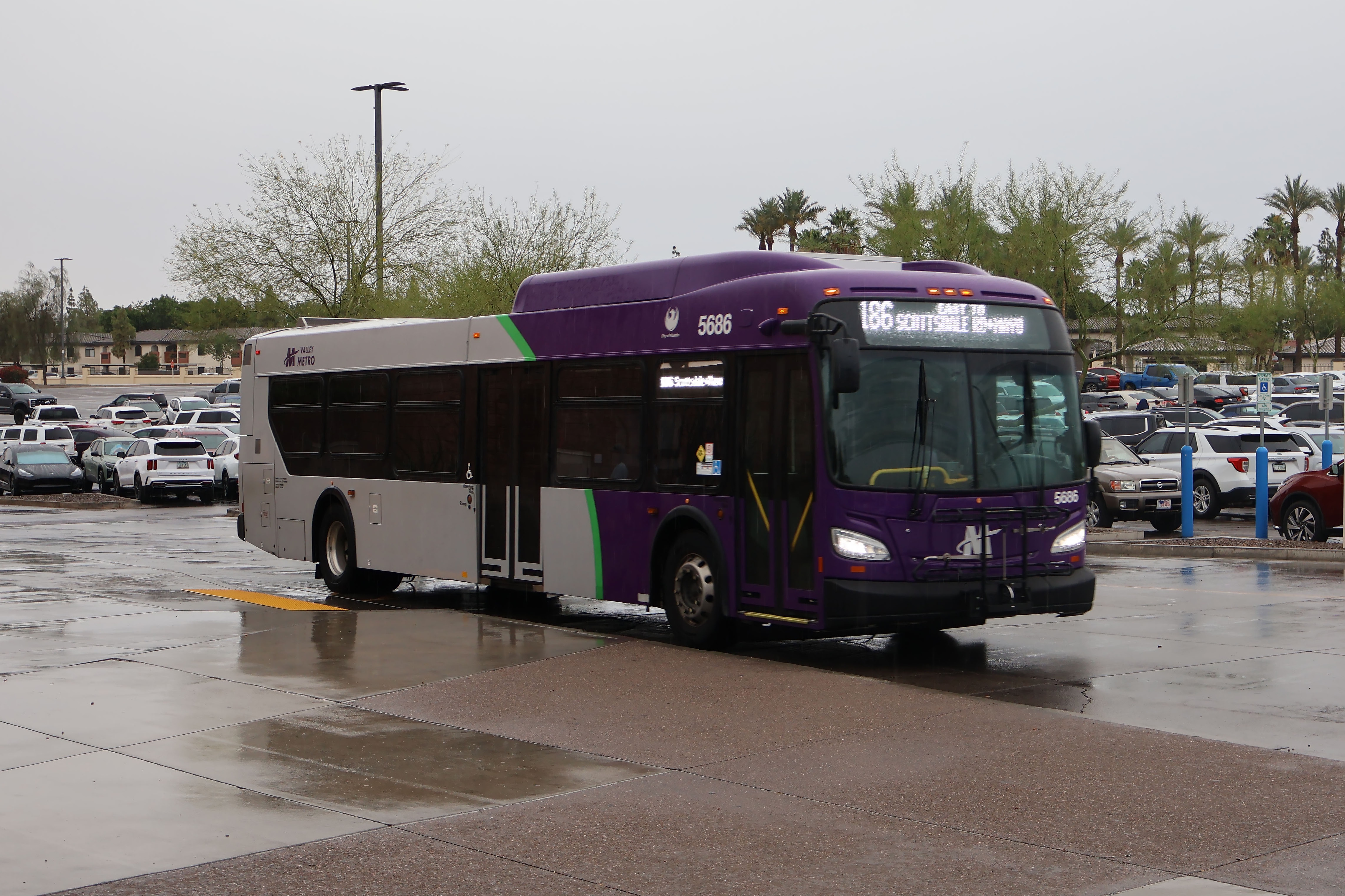 A gray and purple Valley Metro bus, with a green stripe, number 5686, at Arrowhead Mall Transit Center in Glendale on route 186 to Mayo Bouelvard and Scottsdale Road