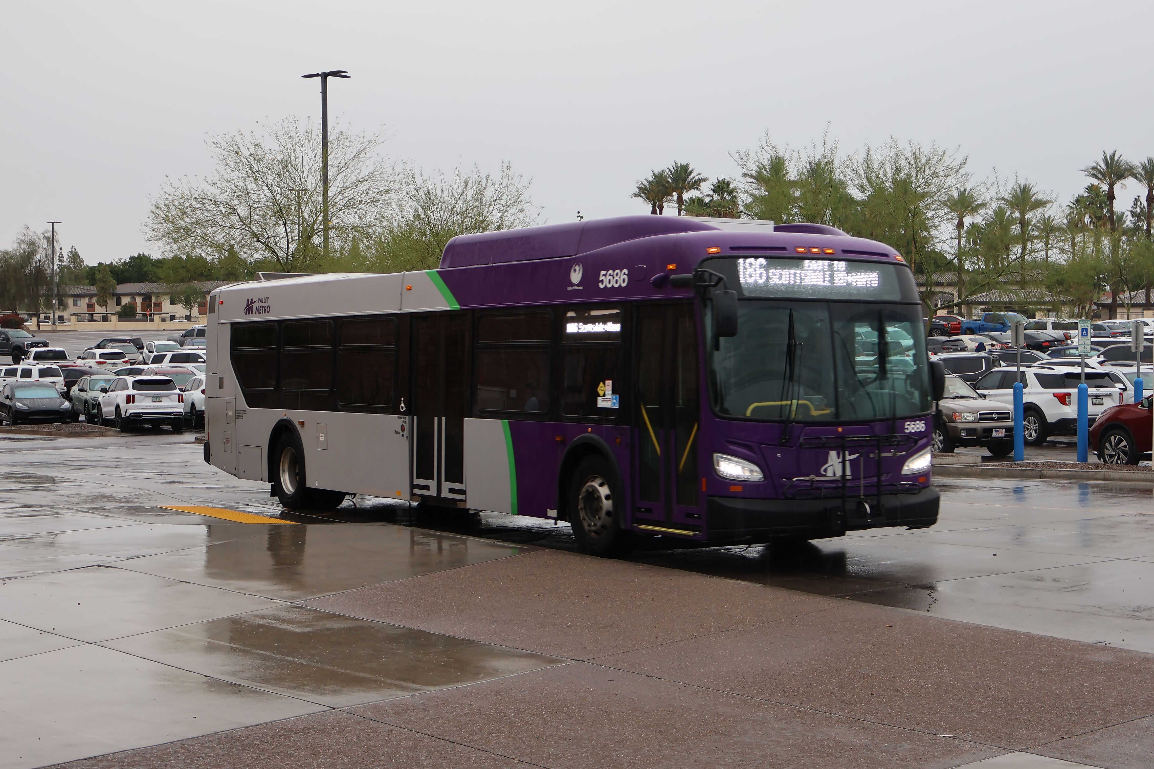 A gray and purple Valley Metro bus, with a green stripe, number 5686, at Arrowhead Mall Transit Center in Glendale on route 186 to Mayo Bouelvard and Scottsdale Road