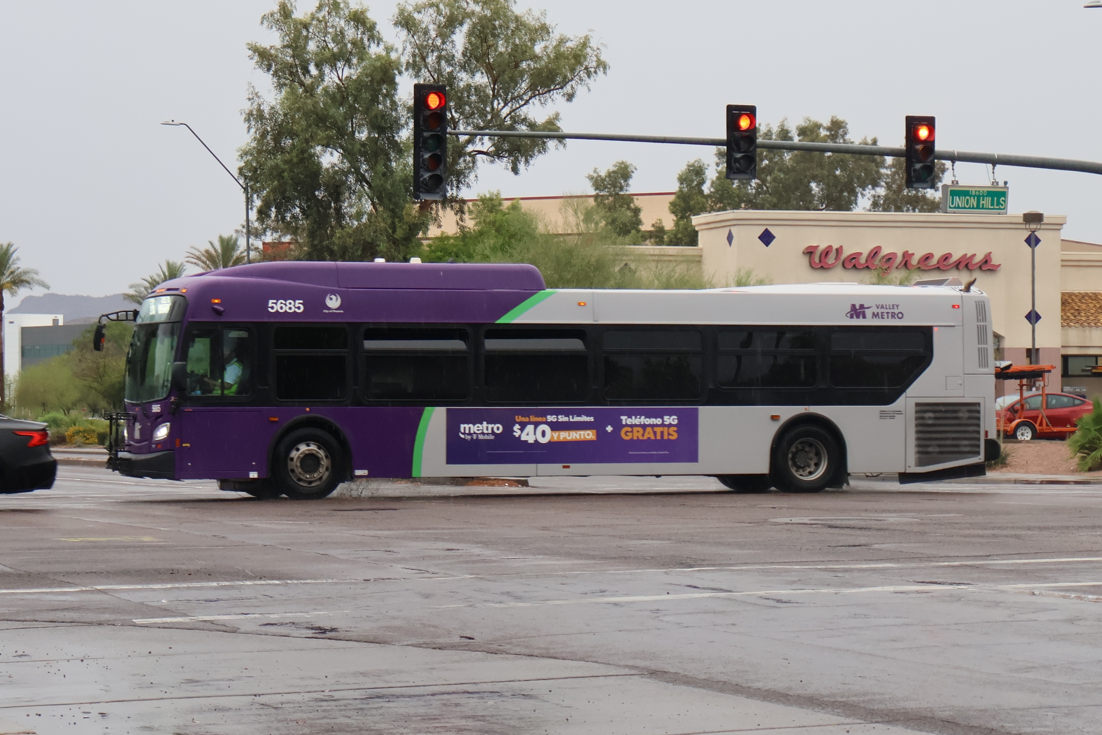 A gray and purple Valley Metro bus, with a green stripe, number 5685, traveling westbound on Union Hills Drive in Glendale on route 186 to Arrowhead Mall Transit Center