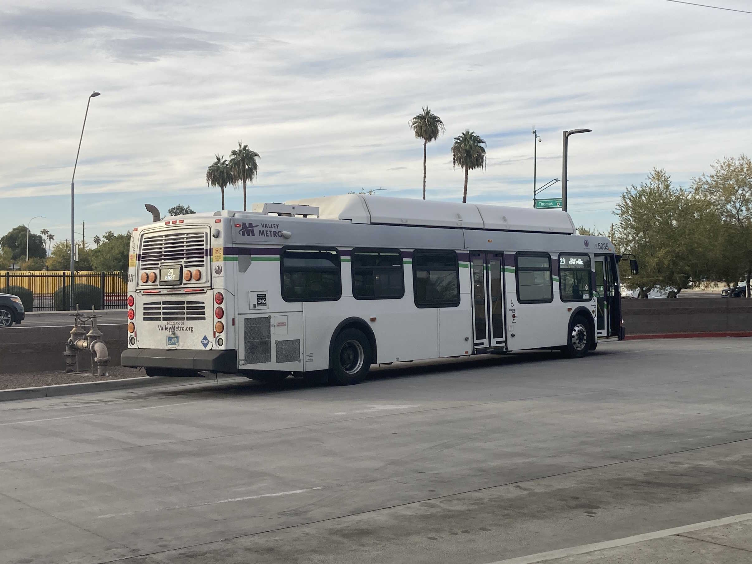 A white and gray Valley Metro bus, with purple and green accent colors, number 5036, at Desert Sky Transit Center in Phoenix on route 29 to Pima Park