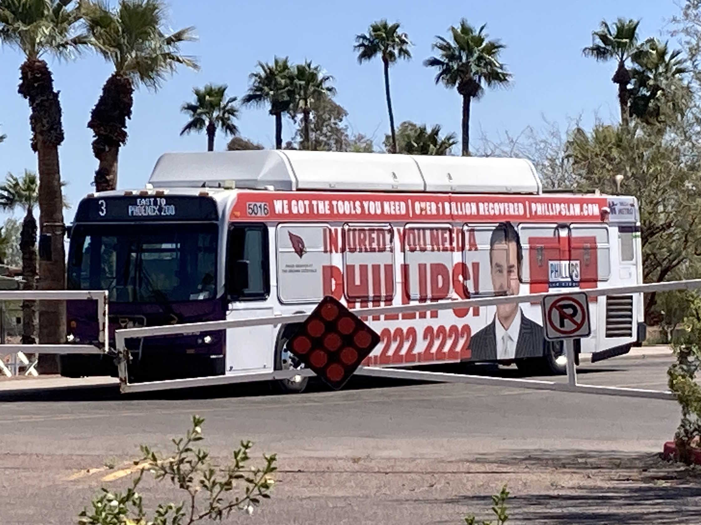 A white and gray Valley Metro bus, with purple and green accent colors, number 5016 in the Phoenix Zoo parking lot on route 3 to Phoenix Zoo