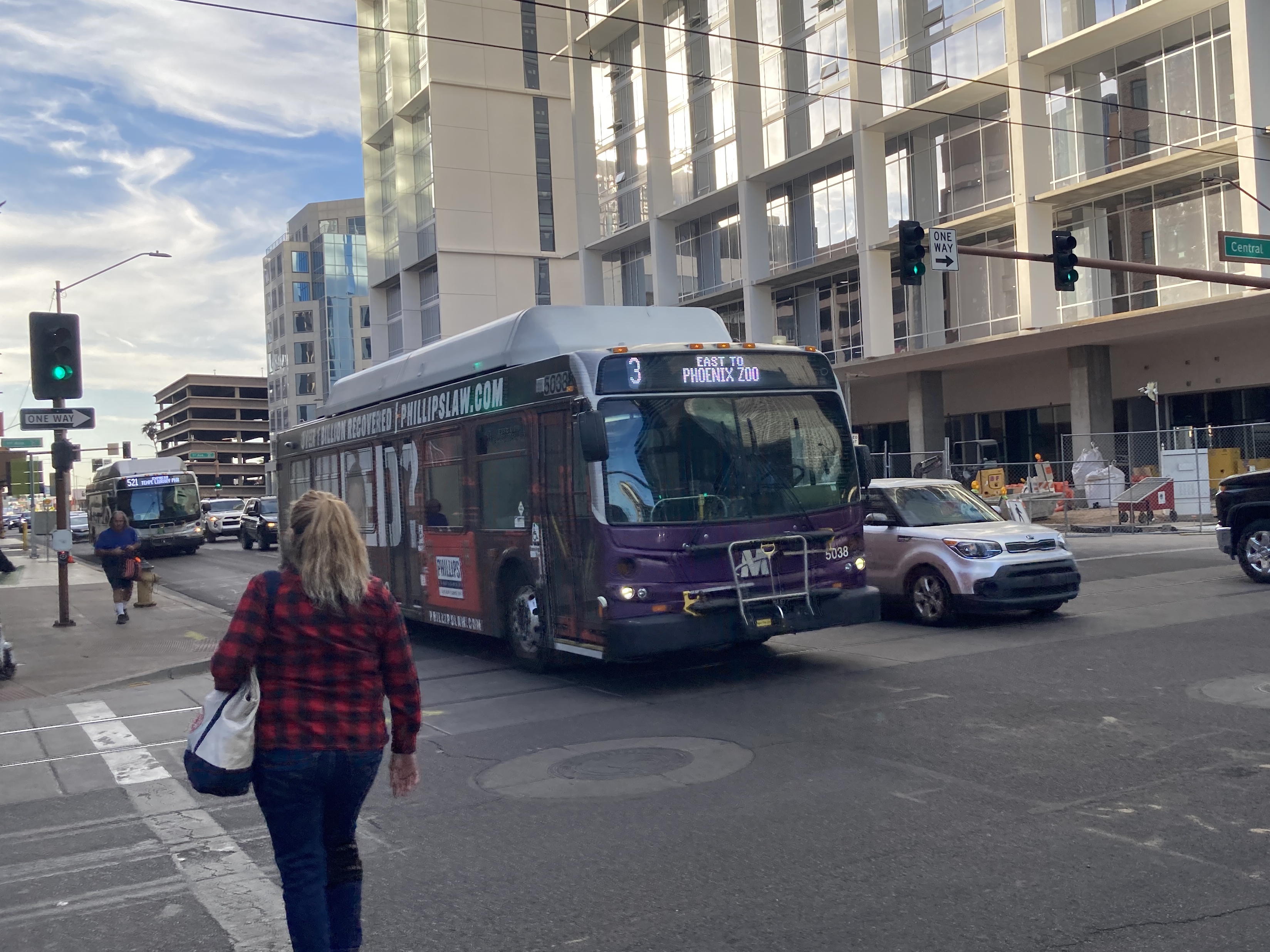 A white and gray Valley Metro bus, with purple and green accent colors, number 5038, traveling eastbound on Van Buren Street in Phoenix on route 3 to the Phoenix Zoo