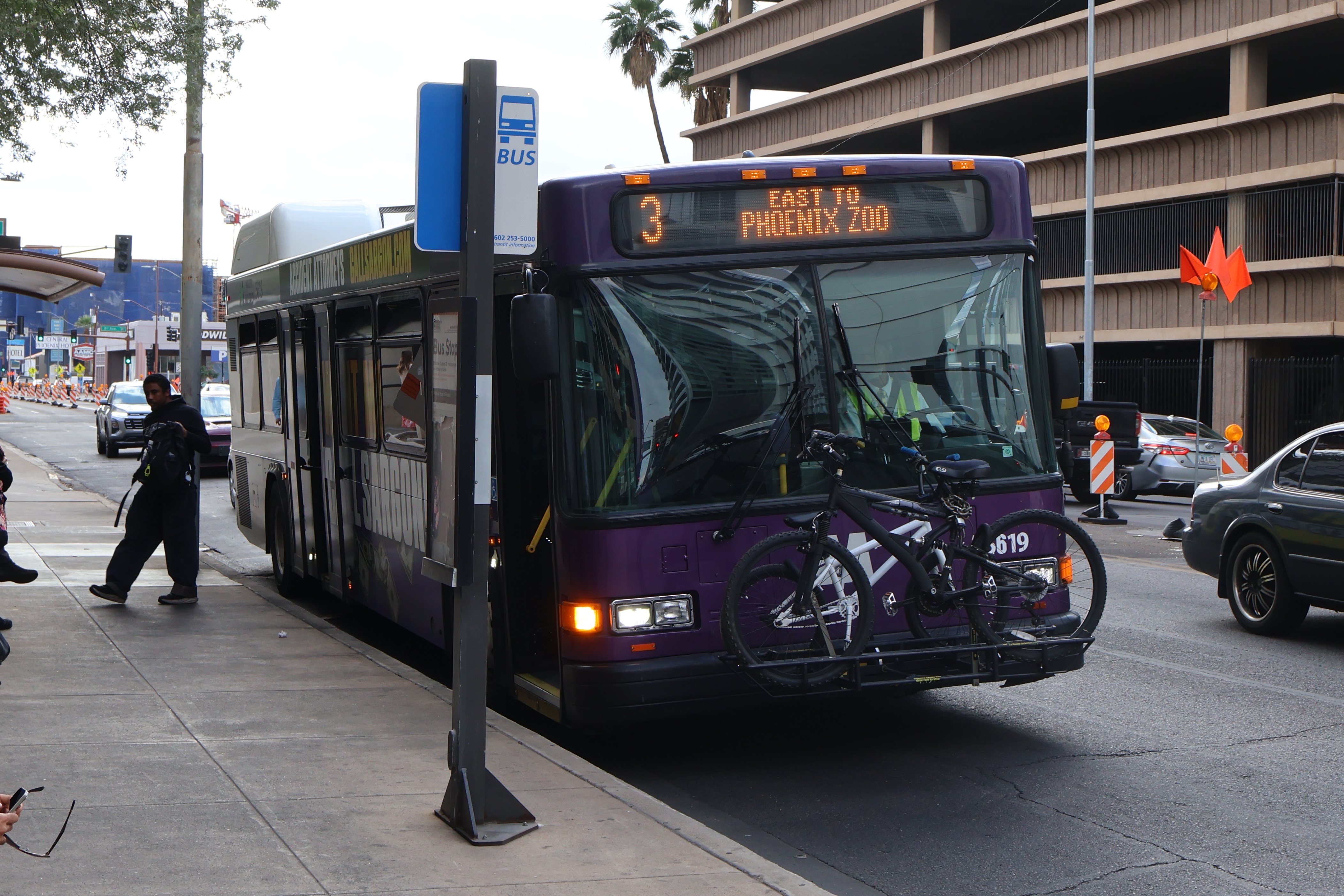 A purple and gray Valley Metro bus, number 5619, traveling eastbound on Van Buren Street in Phoenix on route 3 to Phoenix Zoo