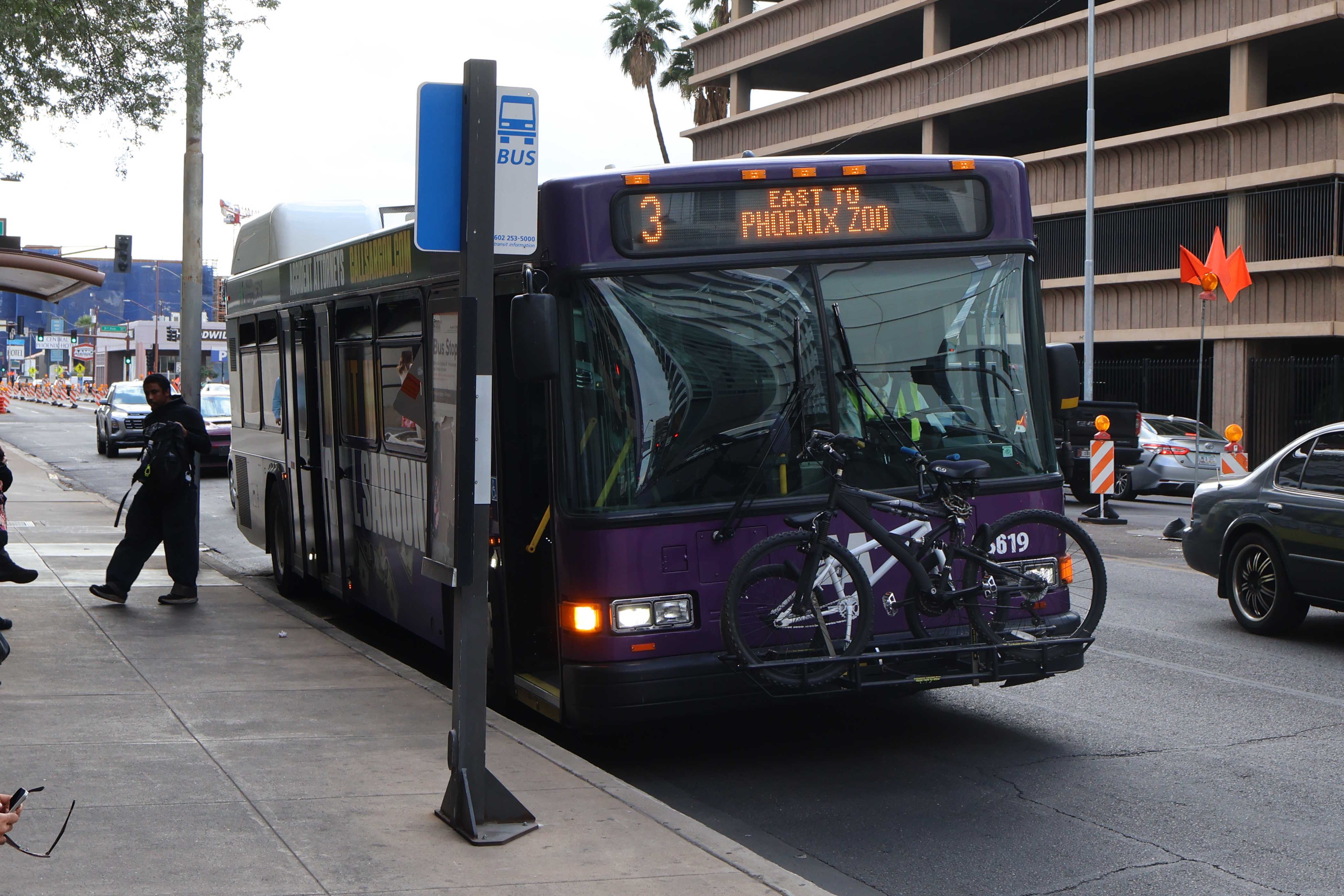 A purple and gray Valley Metro bus, number 5619, traveling eastbound on Van Buren Street in Phoenix on route 3 to Phoenix Zoo
