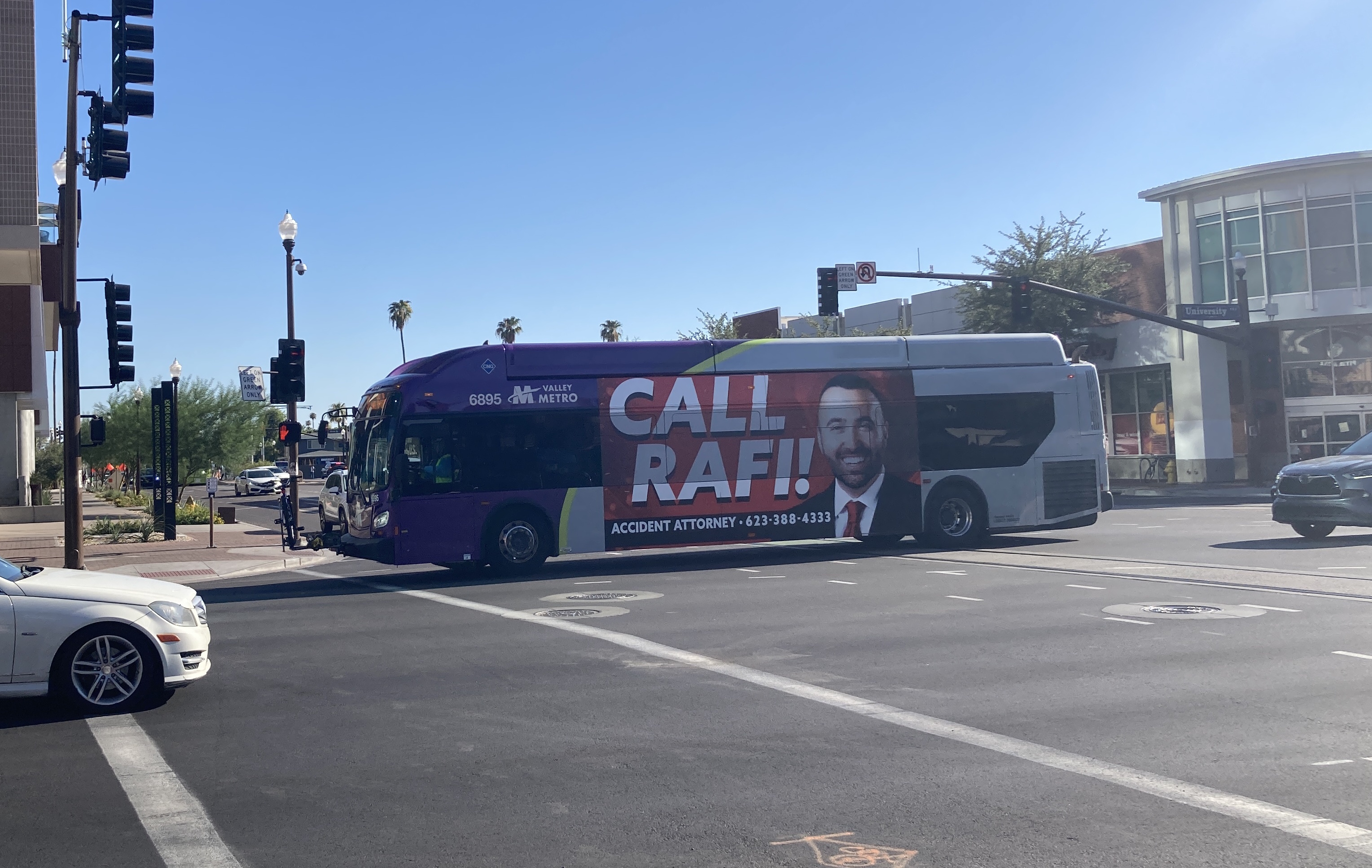 A gray and purple Valley Metro bus, with a green stripe, number 6895, traveling eastbound on University Drive in Tempe on route 30 to Power Road & University Drive