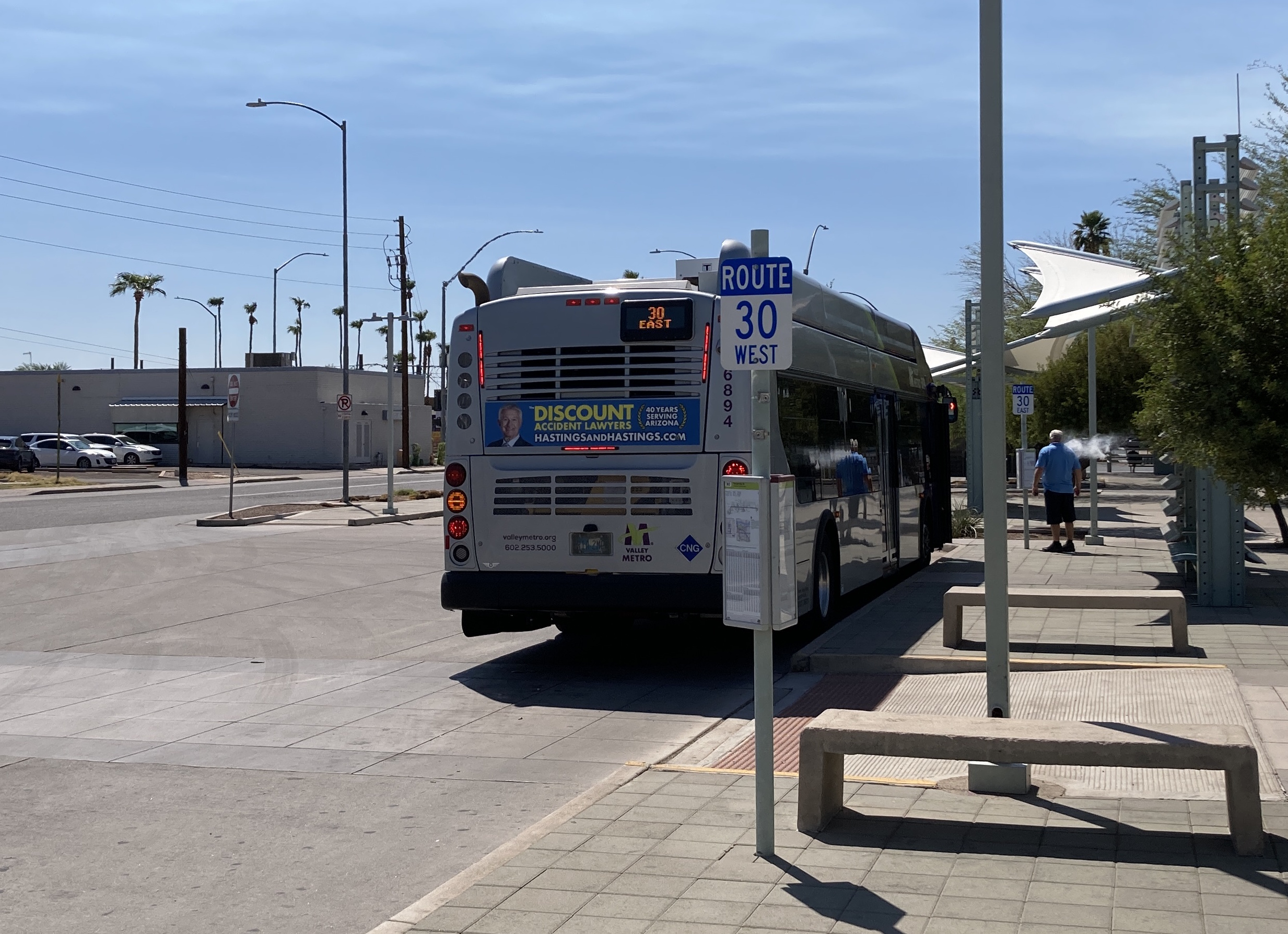 A gray and purple Valley Metro bus, with a green stripe, number 6894, at Sycamore/Main Street Transit Center in Mesa on route 30 to Power Road & University Drive