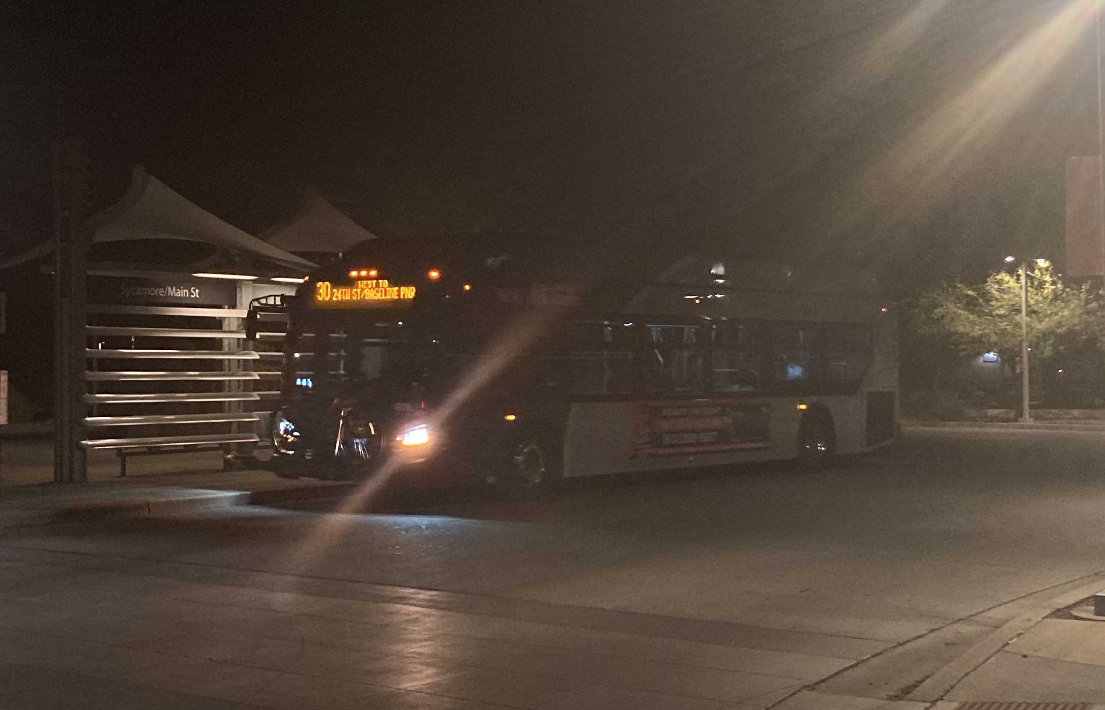 A gray and purple Valley Metro bus, with a green stripe, unknown number, at Sycamore/Main Street Transit Center in Mesa on route 30 to 24th Street/Baseline Park and Ride