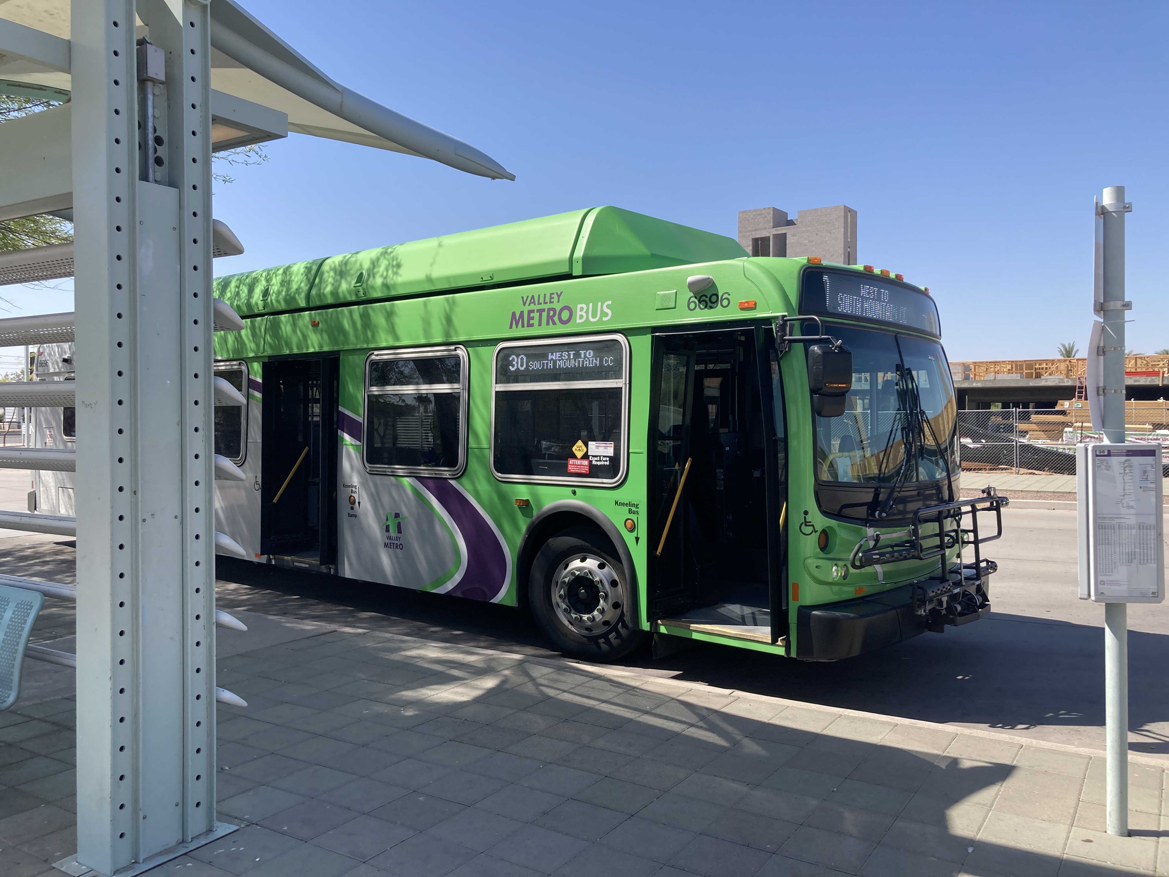 A green and gray Valley Metro bus, with a purple stripe, number 6696, at Sycamore/Main Street Transit Center in Mesa on route 30 to South Mountain Community College