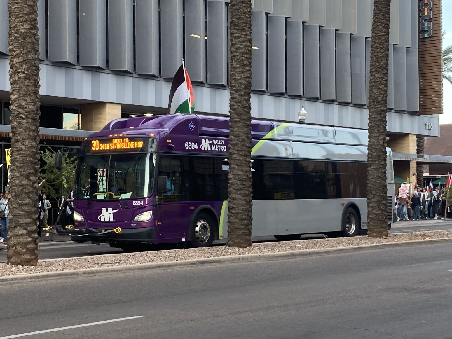 A gray and purple Valley Metro bus, with a green stripe, number 6894, traveling westbound on University Drive in Tempe on route 30 to 24th Street/Baseline Park and Ride