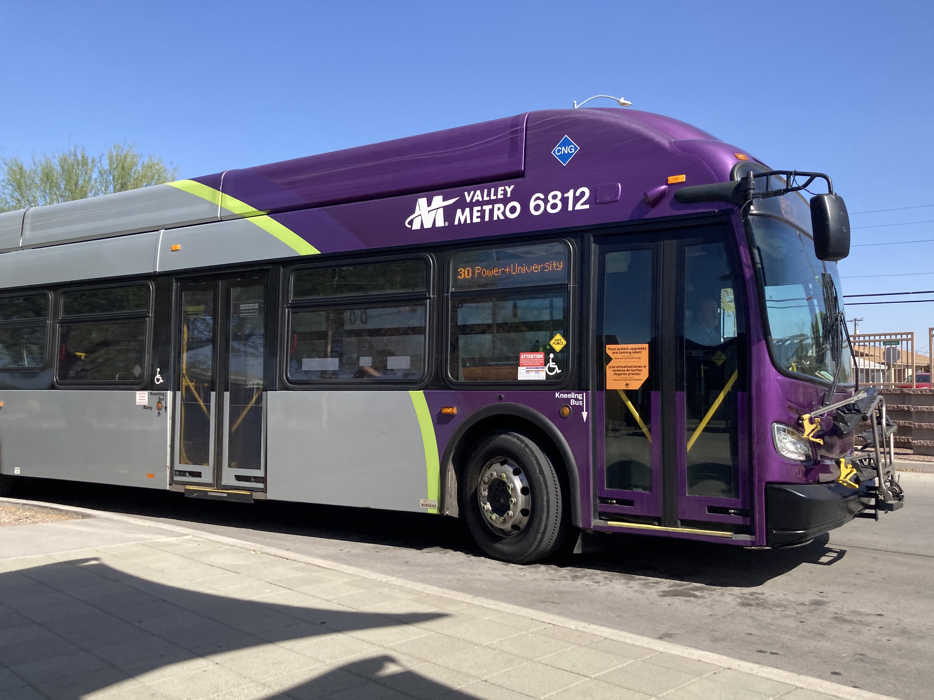 A gray and purple Valley Metro bus, with a green stripe, number 6812, at Sycamore/Main Street Transit Center in Mesa on route 30 to Power Road and University Drive