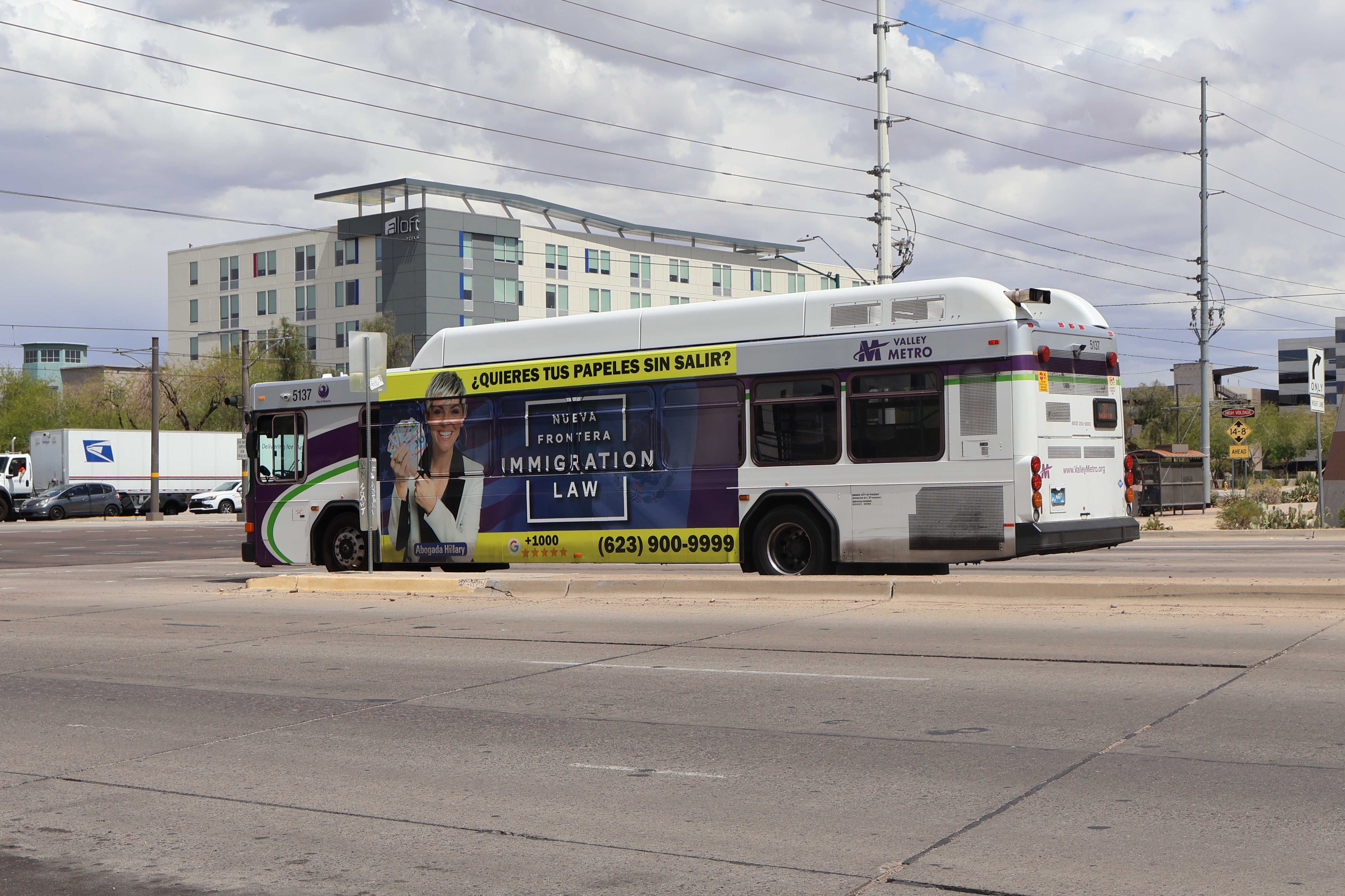 A white and gray Valley Metro bus, with purple and green accent colors, number 5137, traveling northbound on 44th Street in Phoenix on route 32 to Camelback Road and 28th Street