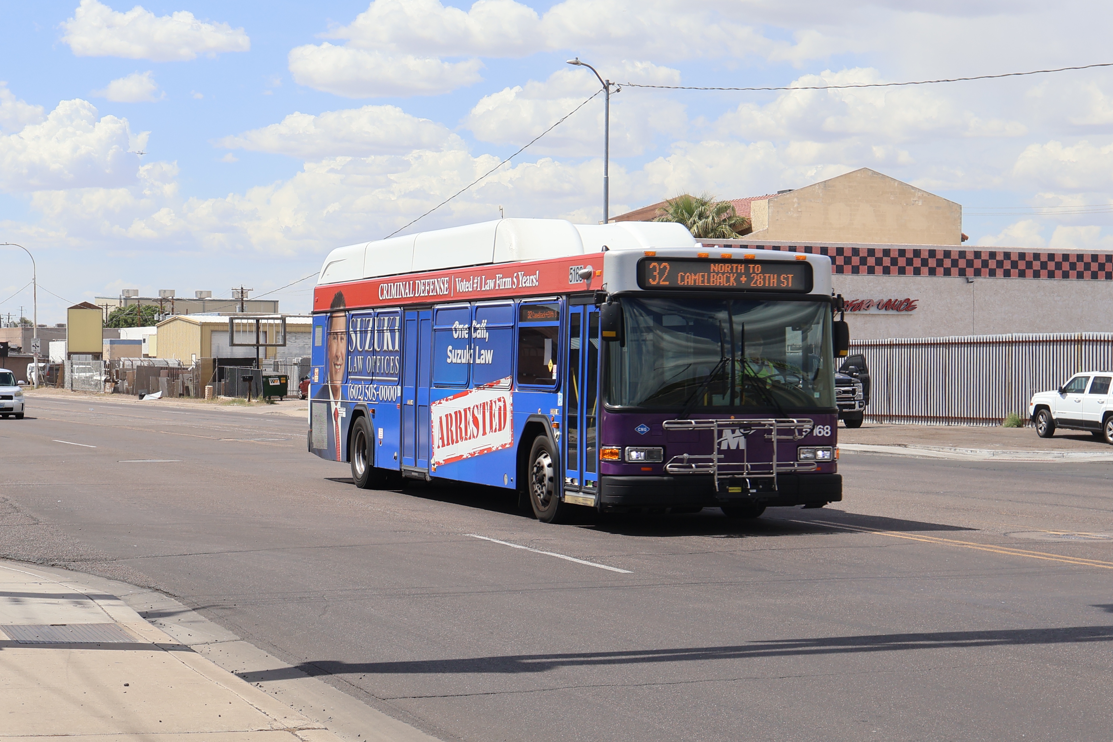 A white and gray Valley Metro bus, with purple and green accent colors, number 5168, traveling eastbound on University Drive in Phoenix on route 32 to Camelback Road and 28th Street