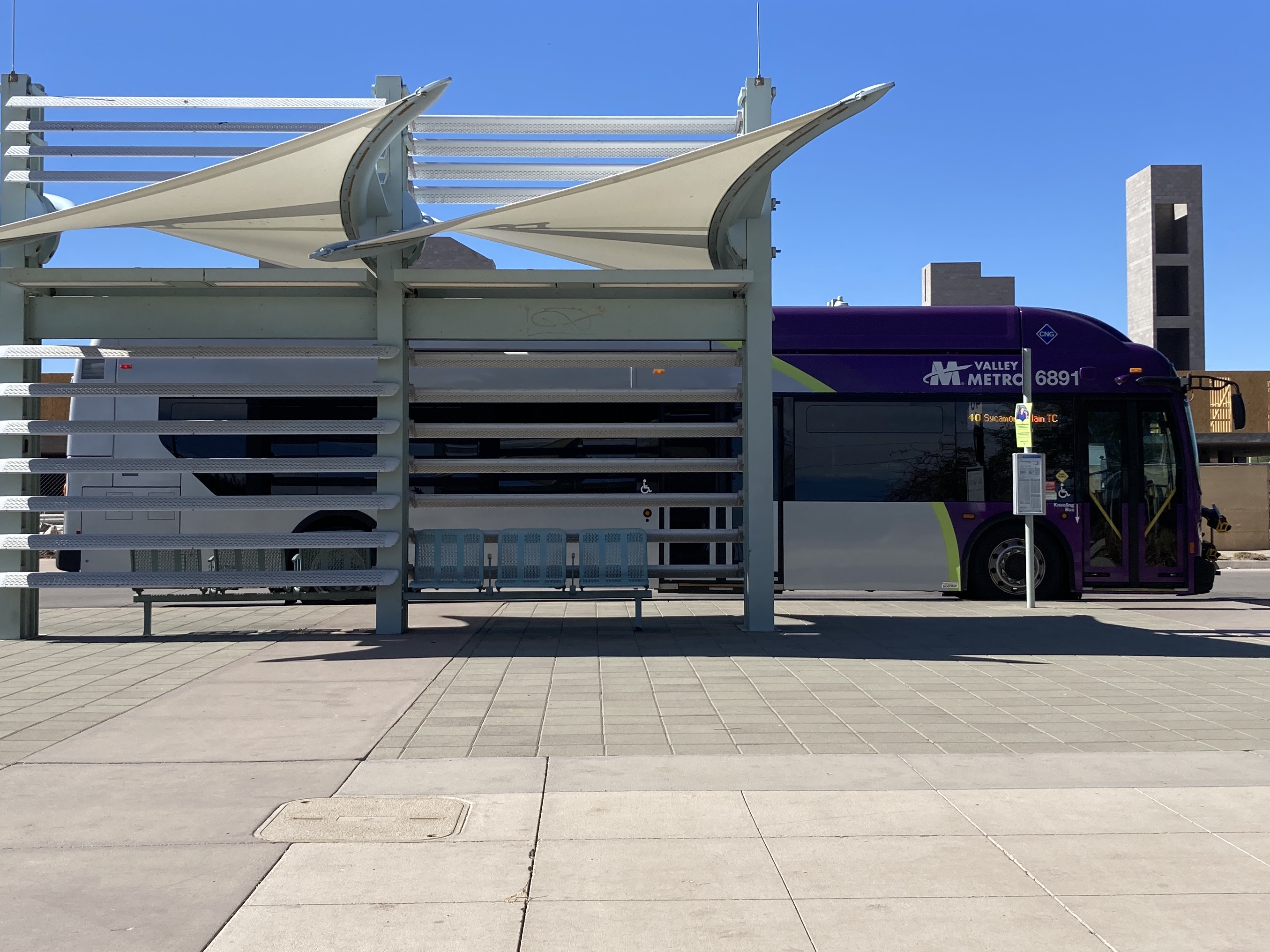 A gray and purple Valley Metro bus, with a green stripe, number 6891, at the Sycamore/Main Street Transit Center, the end of route 40 to Superstition Springs Transit Center