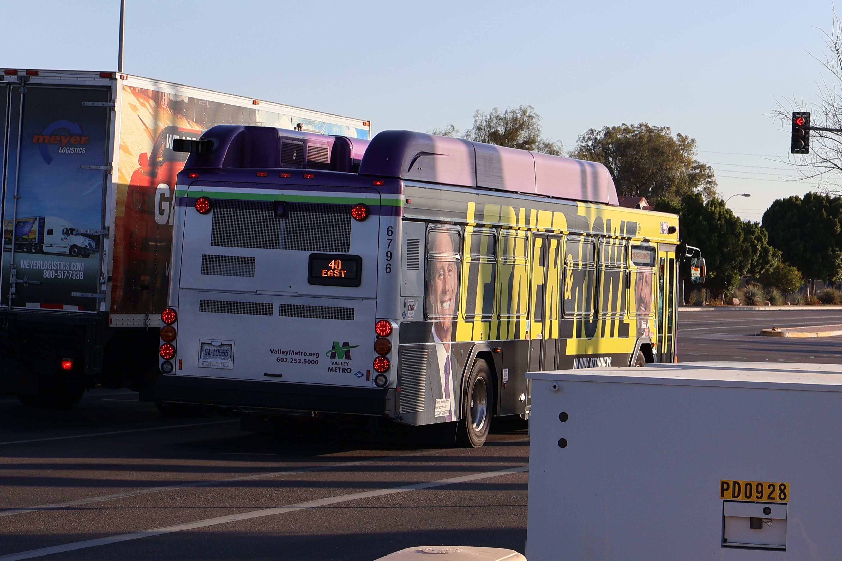 A gray and purple Valley Metro bus, with a white and green stripe, number 6796, traveling eastbound on Main Street in Mesa on route 40 to Superstition Springs Transit Center