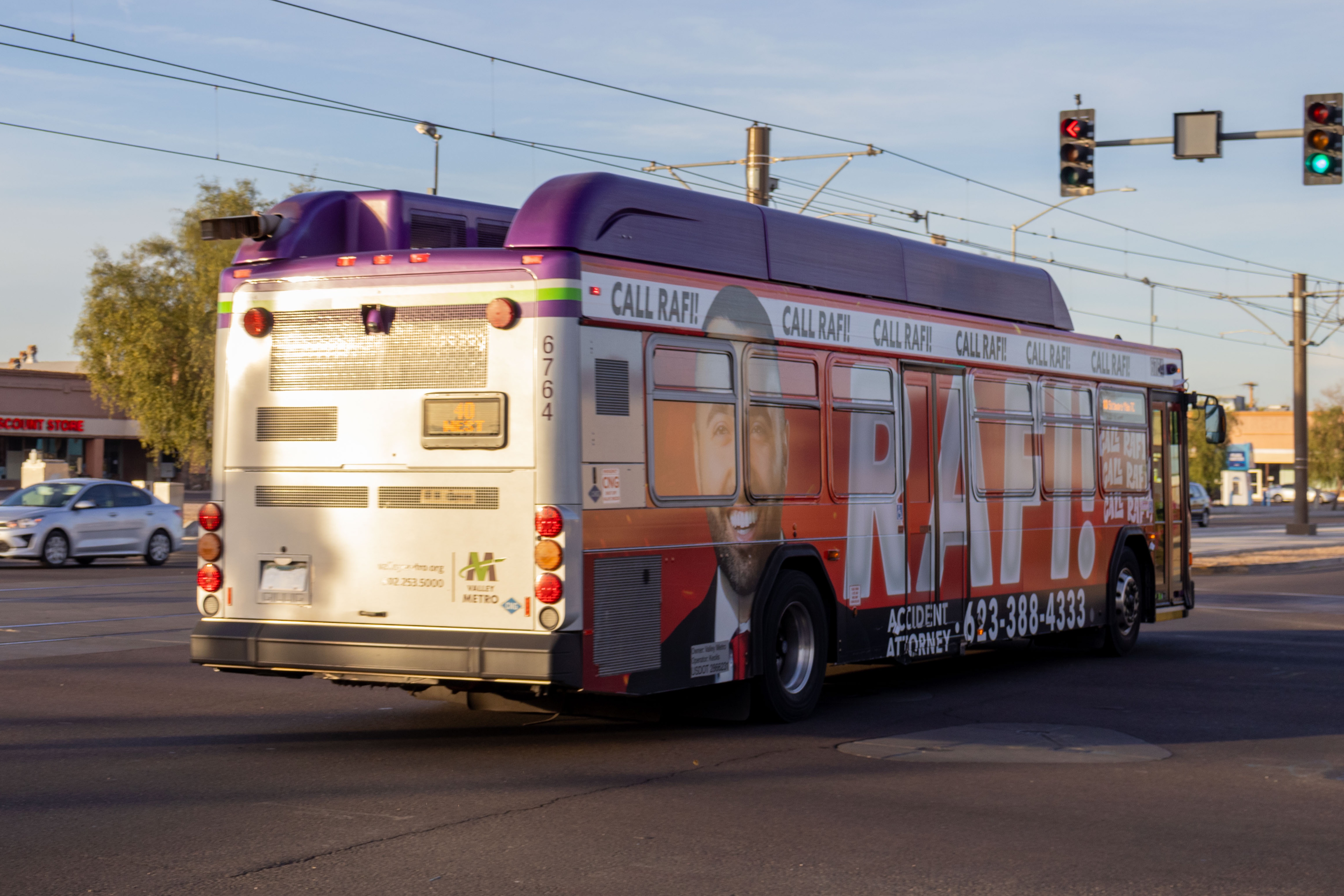 A gray and purple Valley Metro bus, with a white and green stripe, number 6764, traveling westbound on Main Street in Mesa on route 40 to Sycamore/Main Street Transit Center