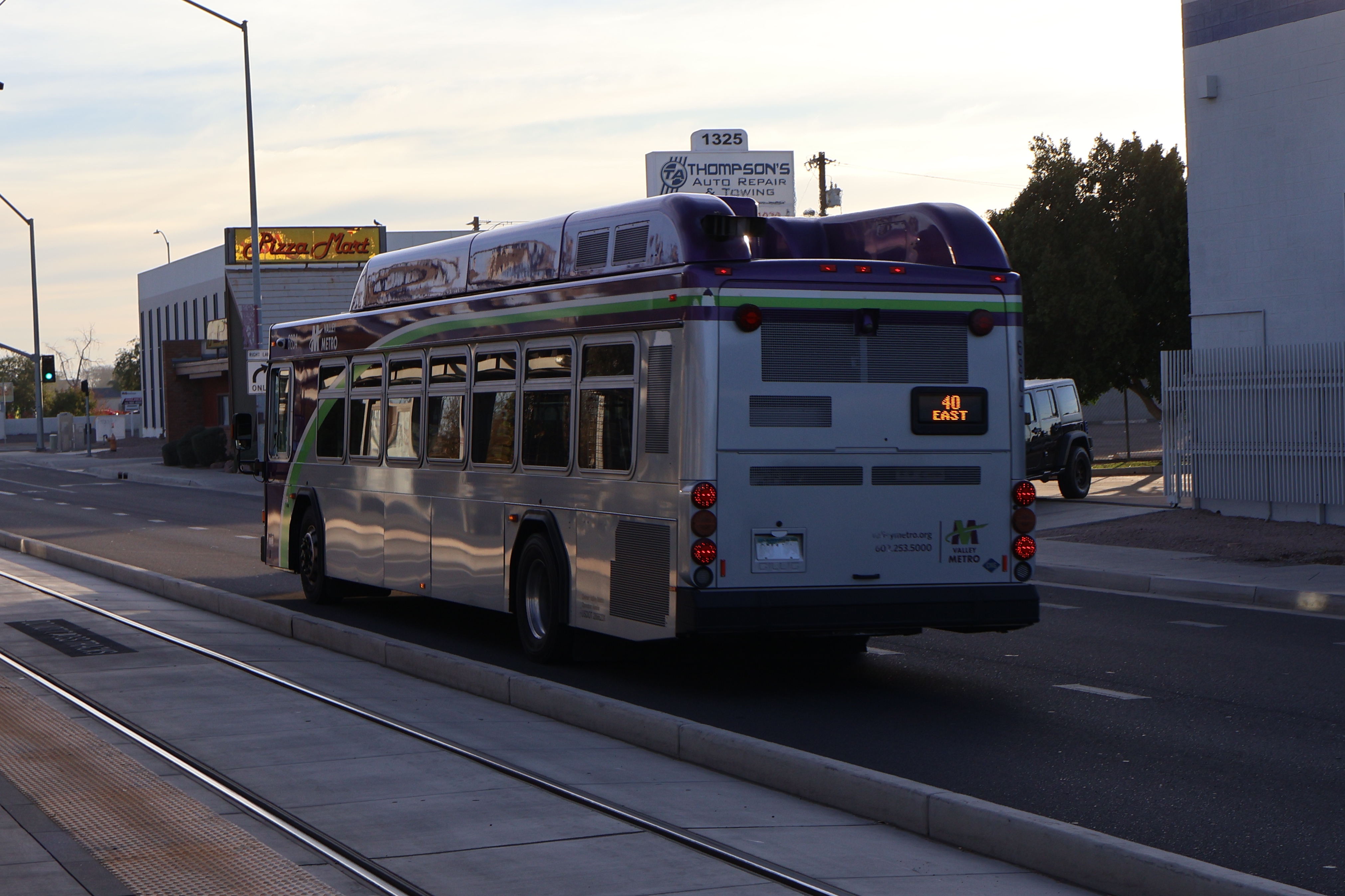 A gray and purple Valley Metro bus, with a white and green stripe, number 6804, traveling eastbound on Main Street in Mesa on route 40 to Superstition Springs Transit Center