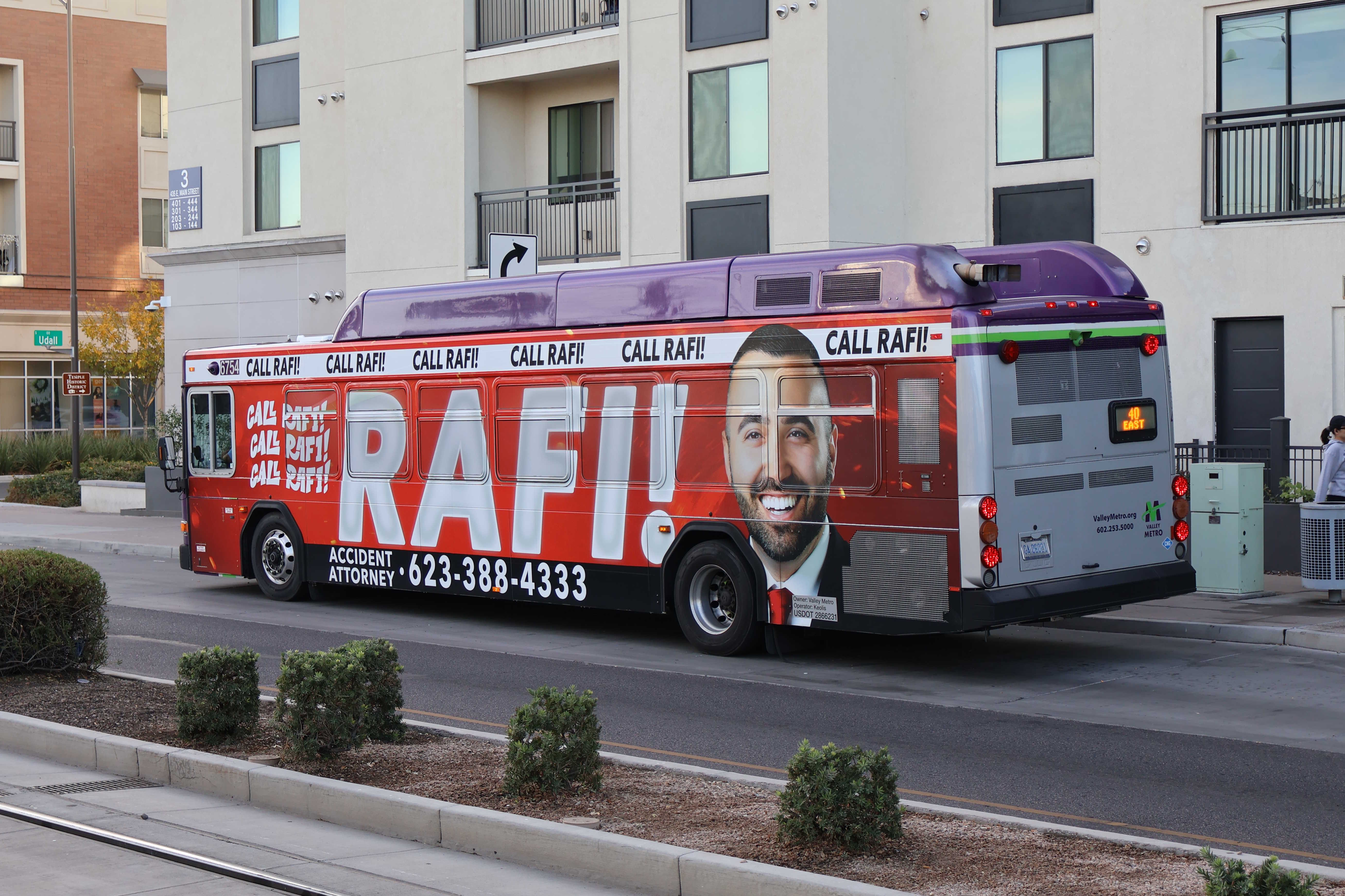 A gray and purple Valley Metro bus, with a white and green stripe, number 6754, traveling eastbound on Main Street in Mesa on route 40 to Superstition Springs Transit Center