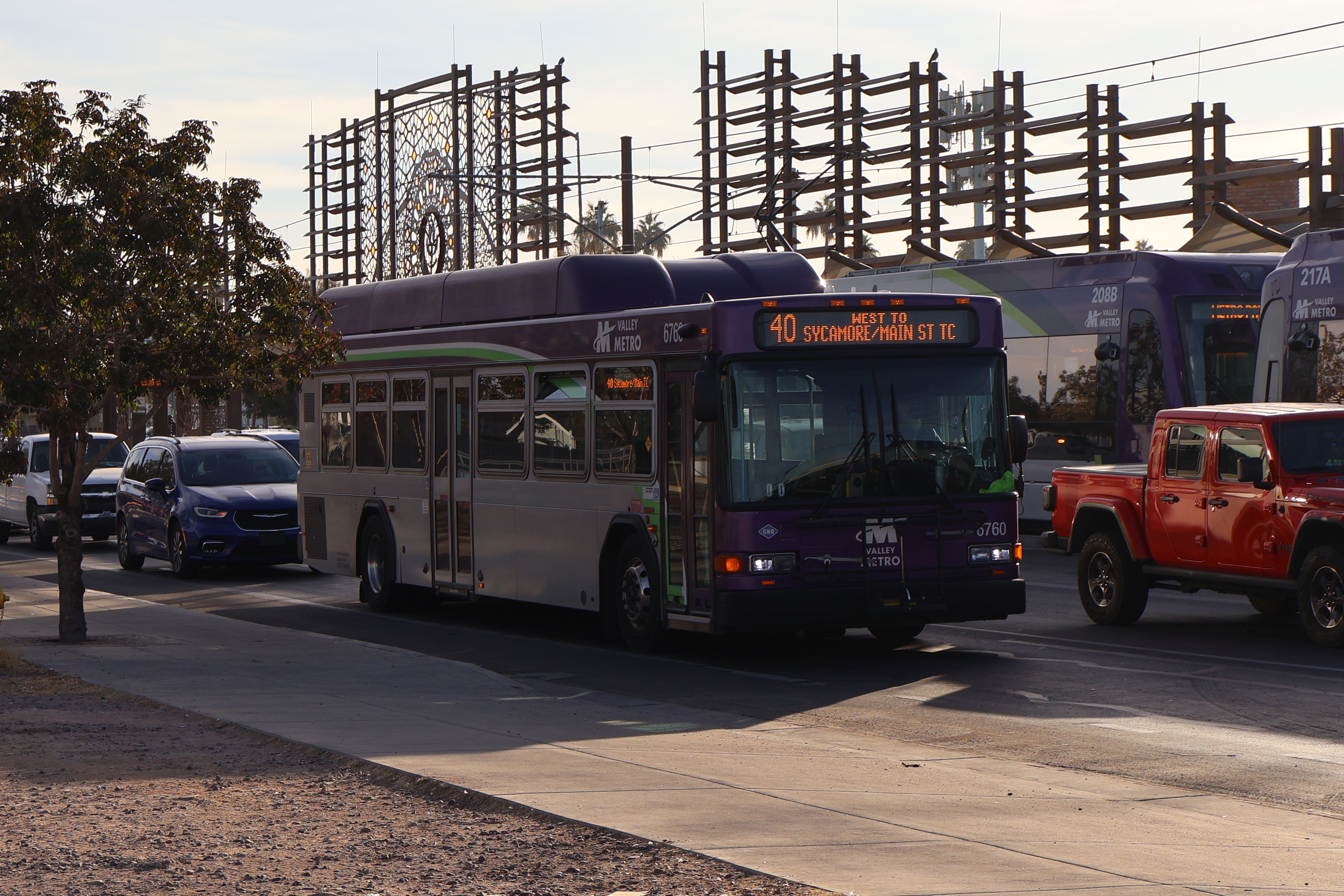 A gray and purple Valley Metro bus, with a white and green stripe, number 6760, traveling westbound on Main Street in Mesa on route 40 to Sycamore/Main Street Transit Center