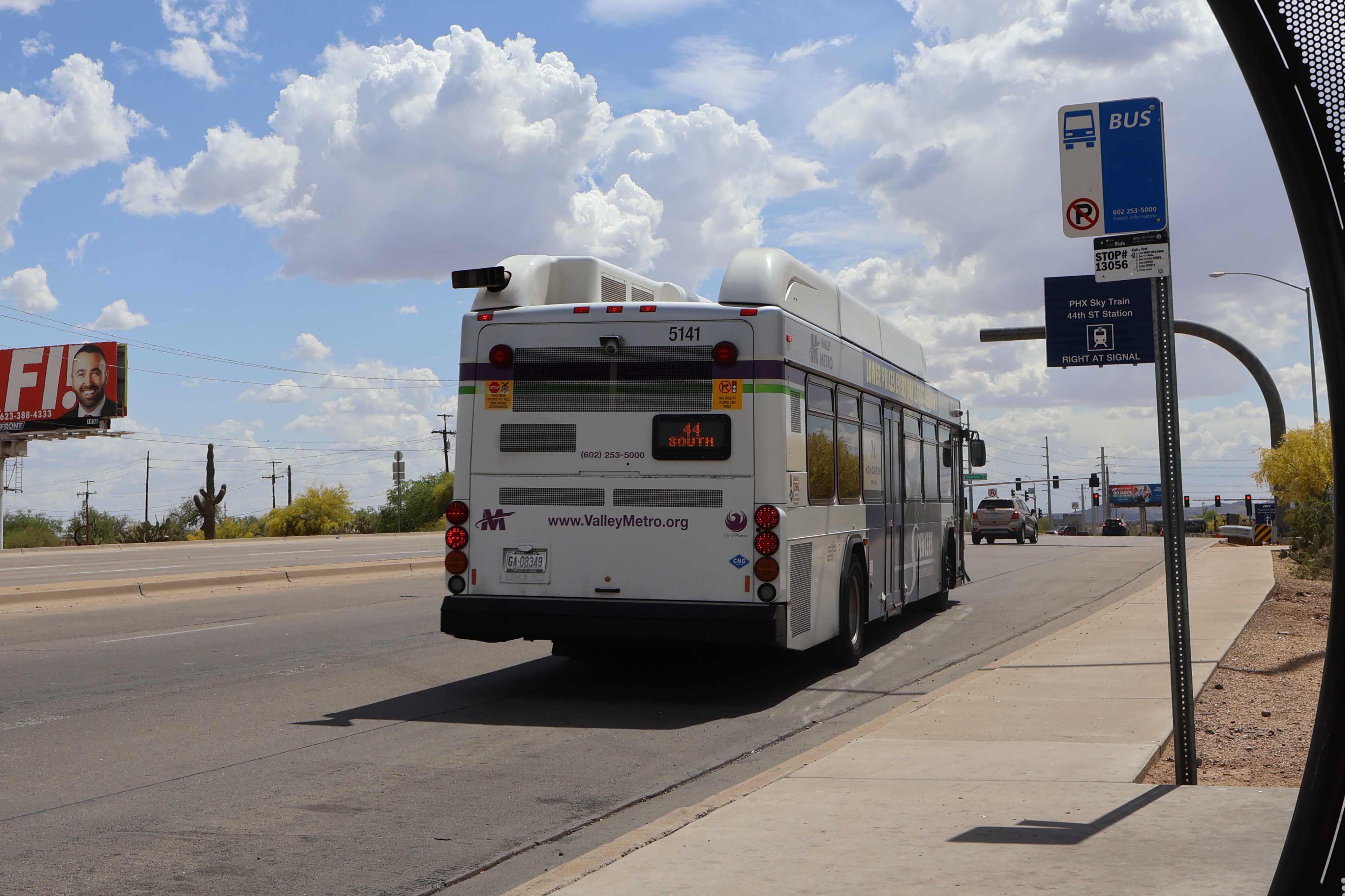 A white and gray Valley Metro bus, with purple and green accent colors, number 5141, traveling southbound on 44th Street in Phoenix on route 44 to 44th Street Sky Train Station