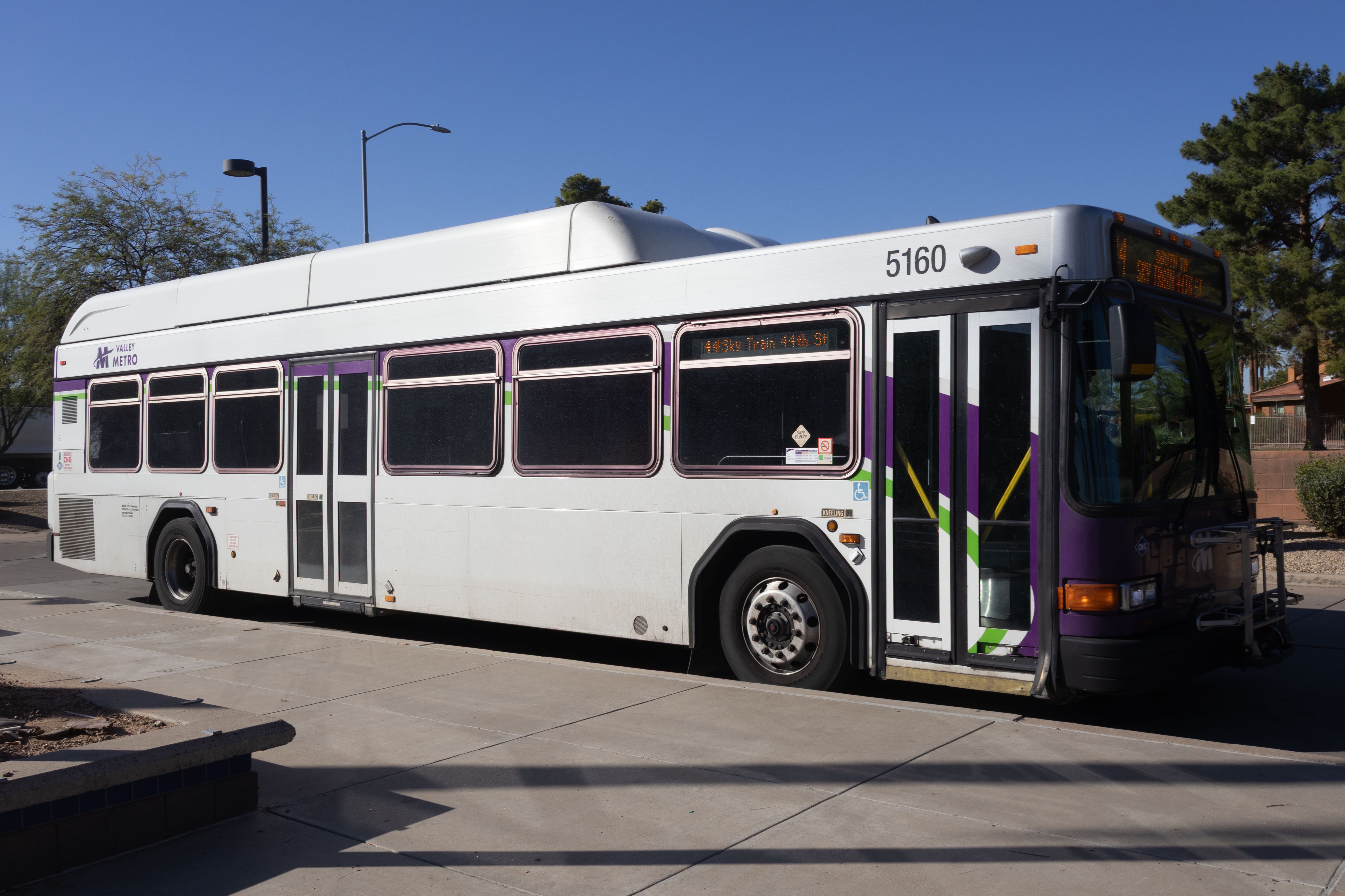 A white and gray Valley Metro bus, with purple and green accent colors, number 5160, at Paradise Valley Transit Center in Phoenix on route 44 to 44th Street Sky Train Station
