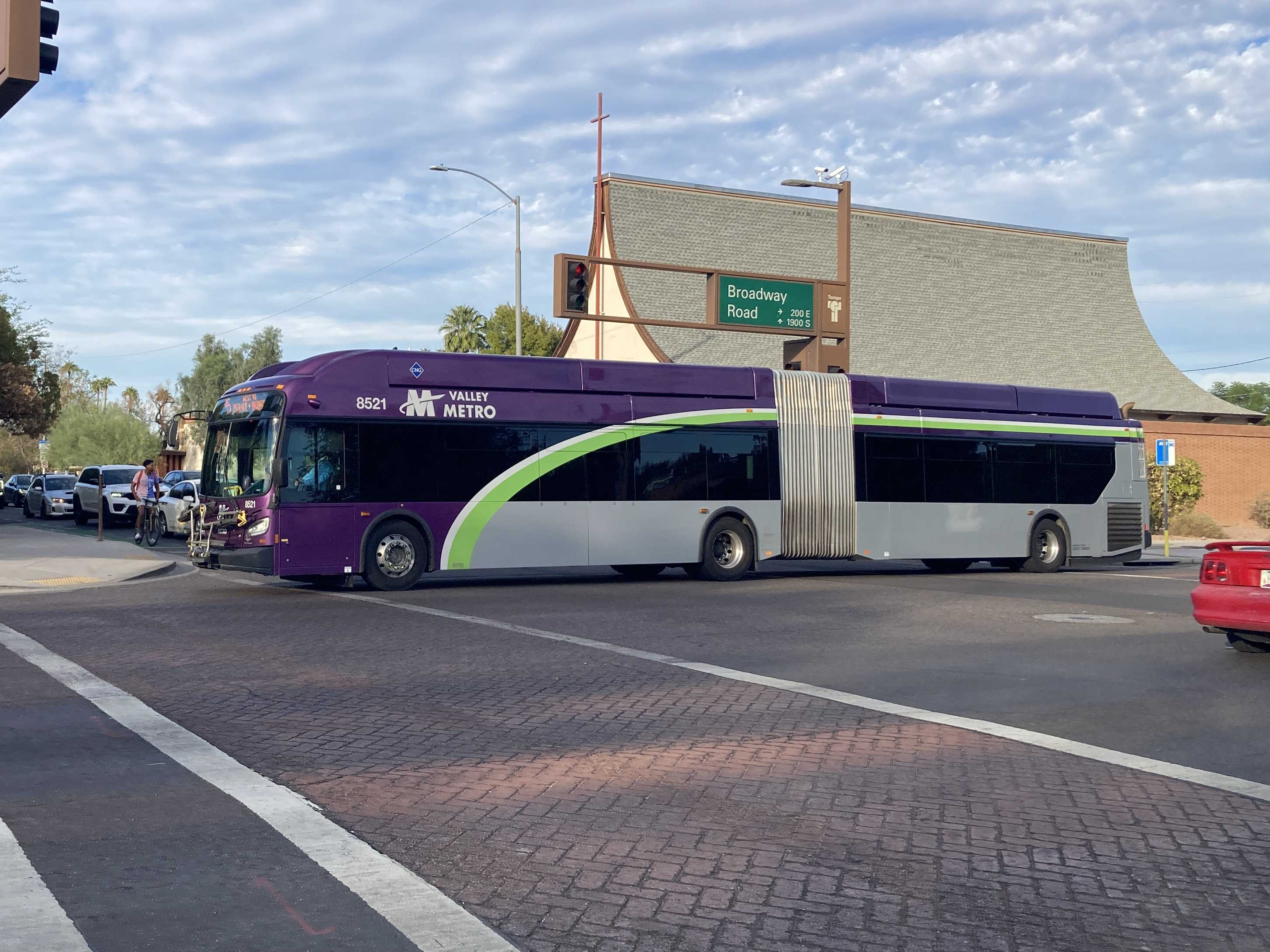 A gray and purple articulated Valley Metro bus with a green and white stripe, number 8521, traveling westbound on Broadway Road in Tempe on route 45 to Broadway Road and 19th Avenue