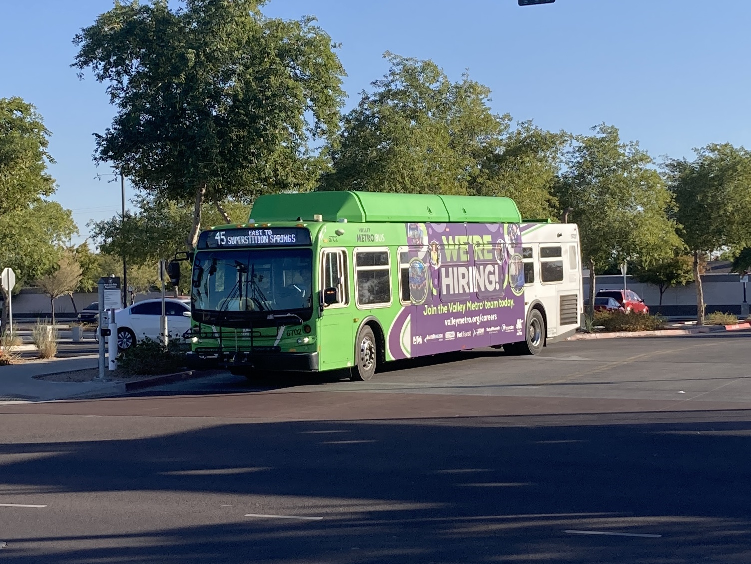 A gray and green Valley Metro bus, number 6702, at the Gilbert Rd/Main St Park and Ride in Mesa on route 45 to Superstition Springs Transit Center