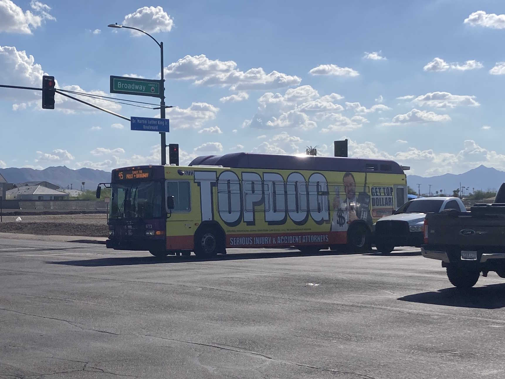 A gray and purple Valley Metro bus, with a white and green stripe, number 6773, traveling eastbound on Broadway Road in Phoenix on route 45 to Broadway Road and Price Road