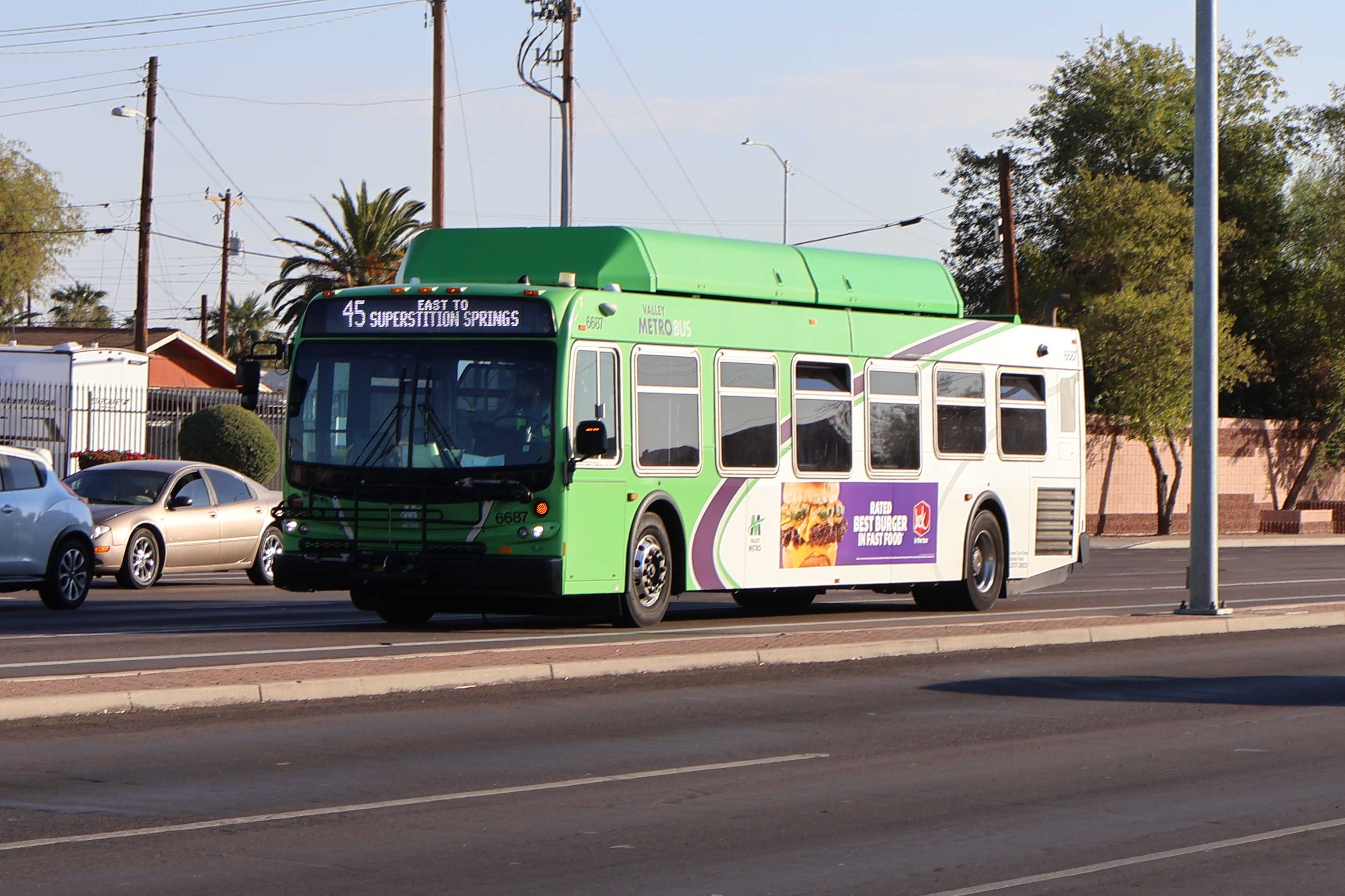 A gray and green Valley Metro bus, number 6687, traveling northbound on Gilbert Road in Mesa on route 45 to Superstition Springs Transit Center