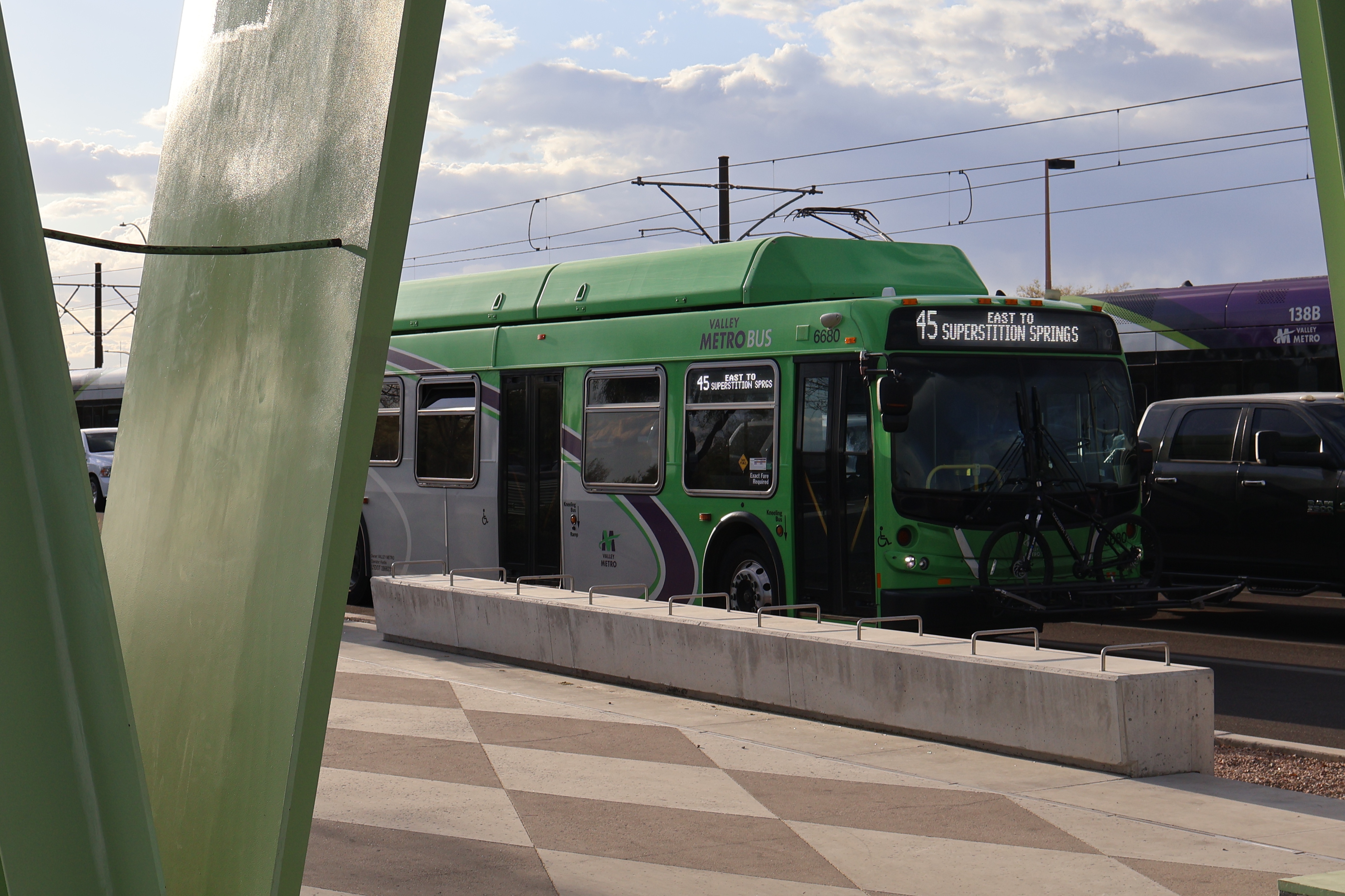 A gray and green Valley Metro bus, number 6680, traveling eastbound on Main Street in Mesa on route 45 to Superstition Springs Transit Center